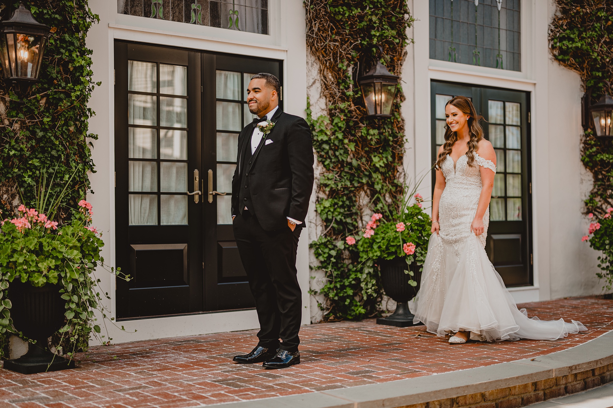 bride approaches groom for first look on brick patio at David's Country Inn