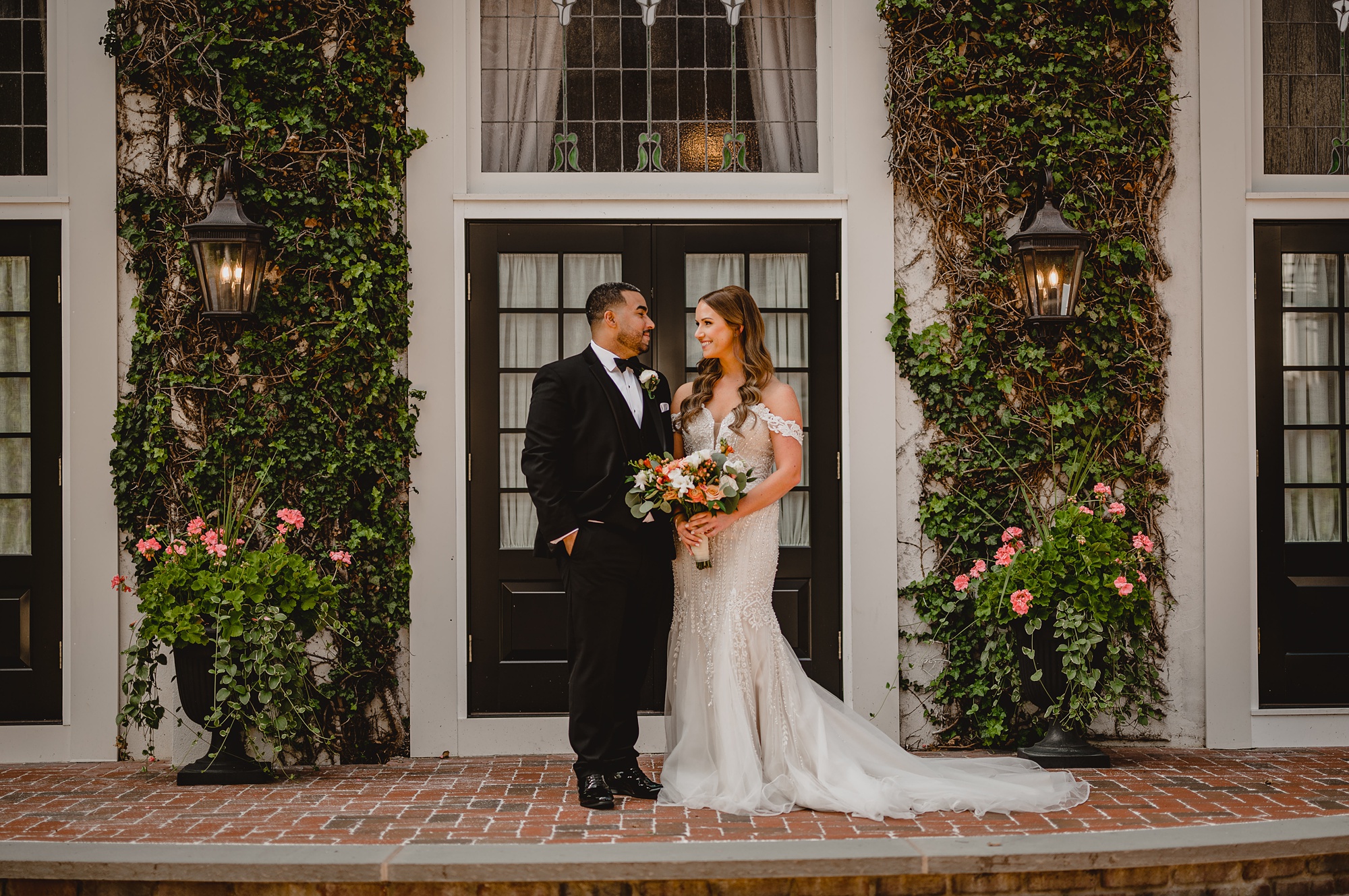 bride and groom smile in front of doors at David's Country Inn