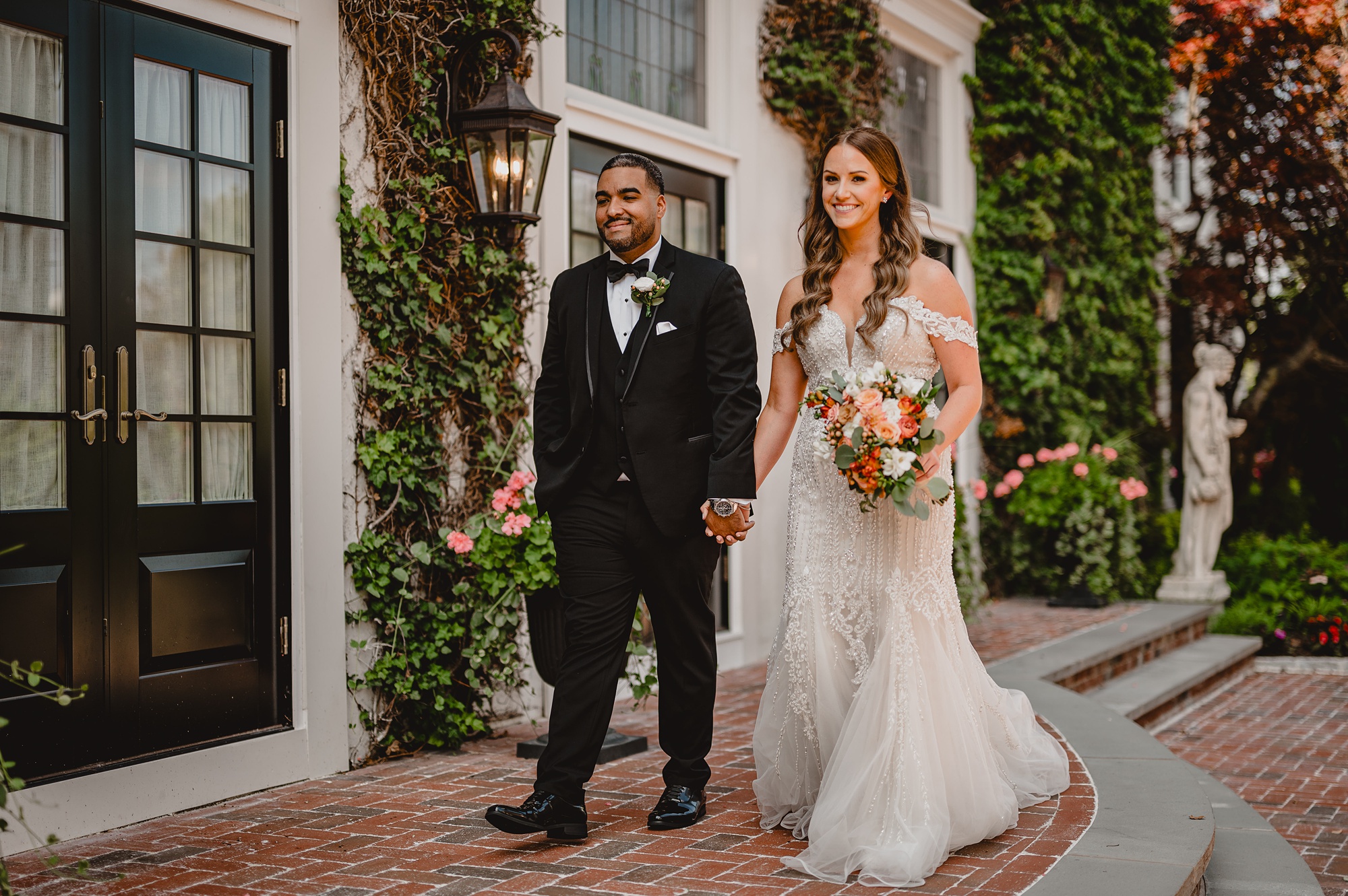 bride and groom hold hands walking on brick patio at David's Country Inn