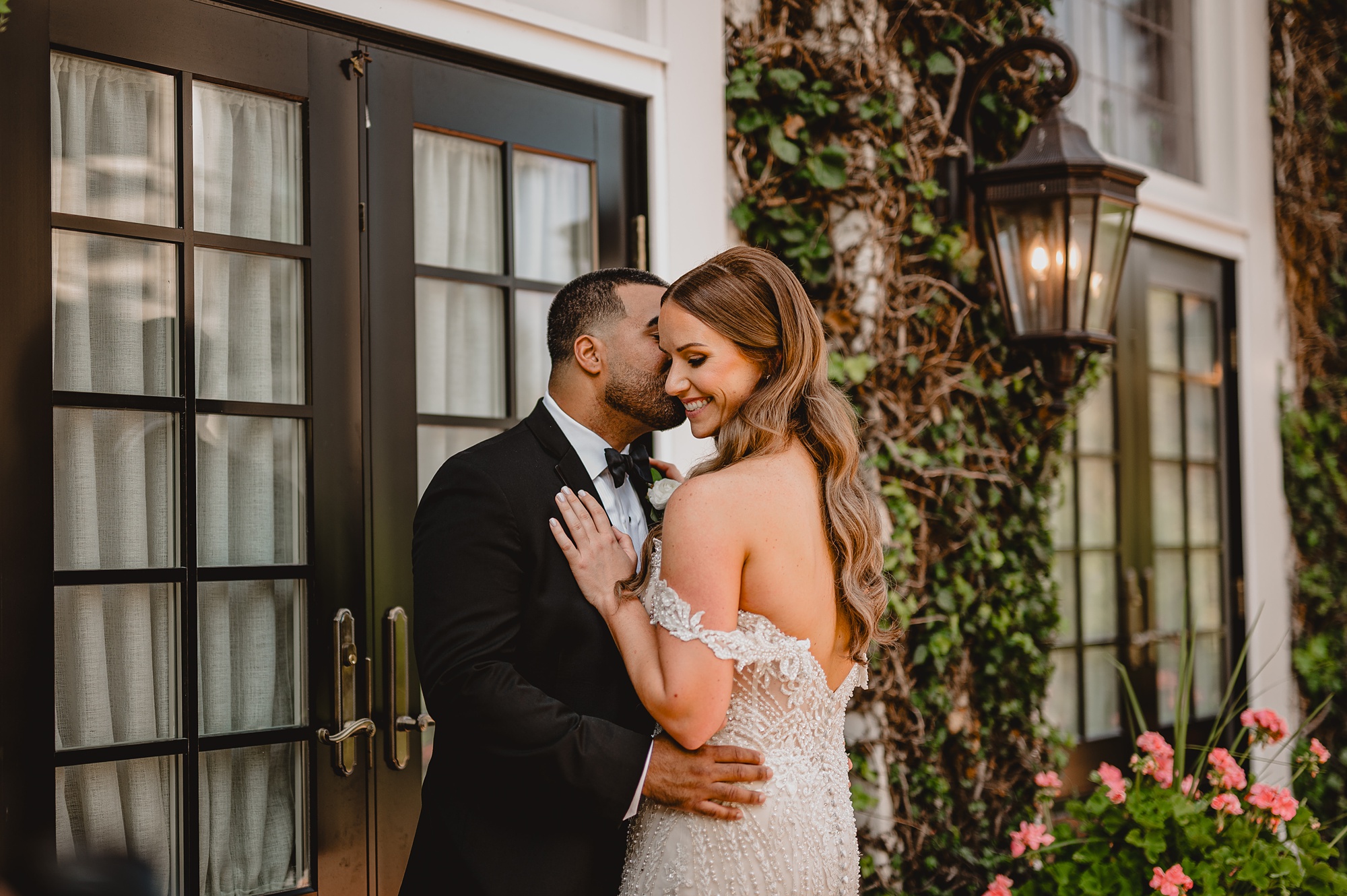 groom kisses bride's cheek outside David's Country Inn