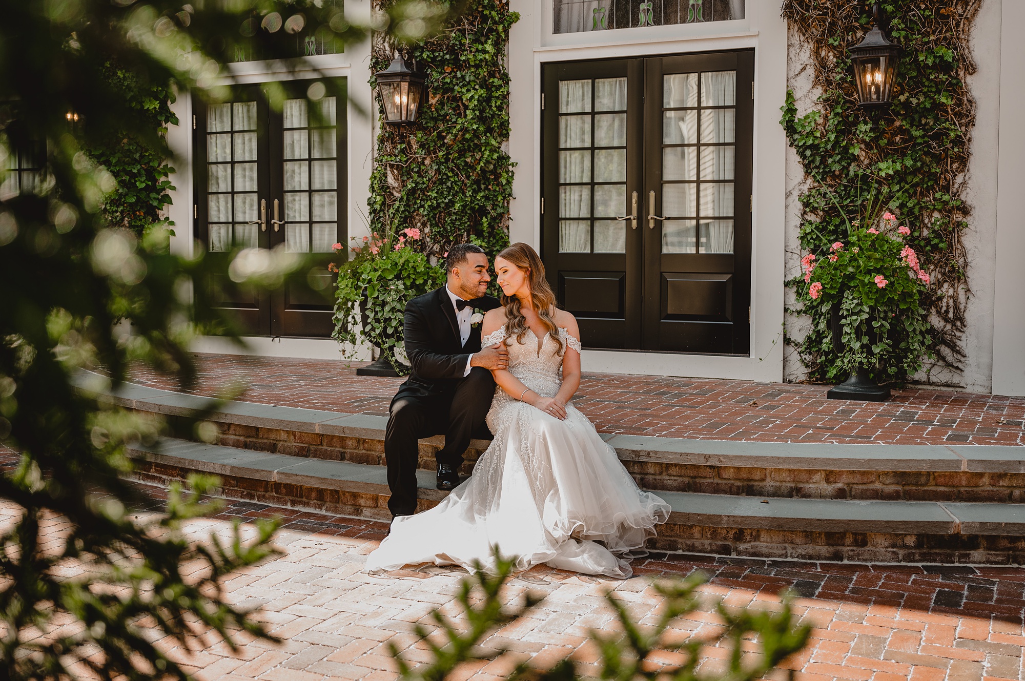newlyweds sit on brick steps of patio at David's Country Inn