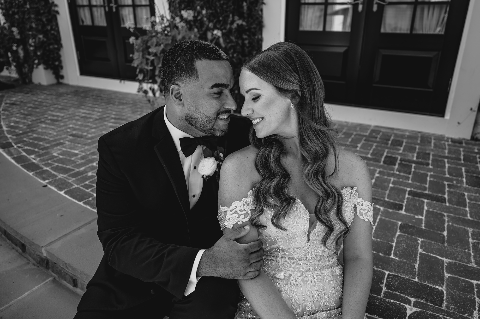 newlyweds hug leaning heads together smiling on steps