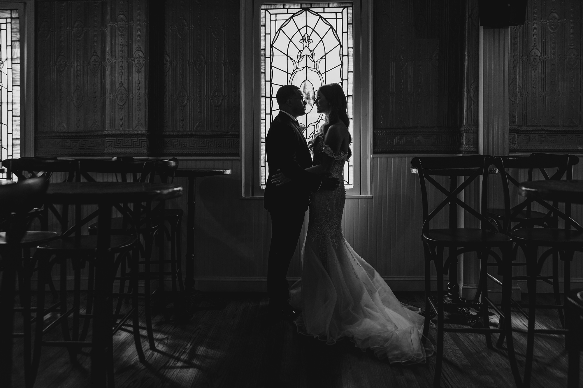 newlyweds pose in front of stained glass wedding at David's Country Inn