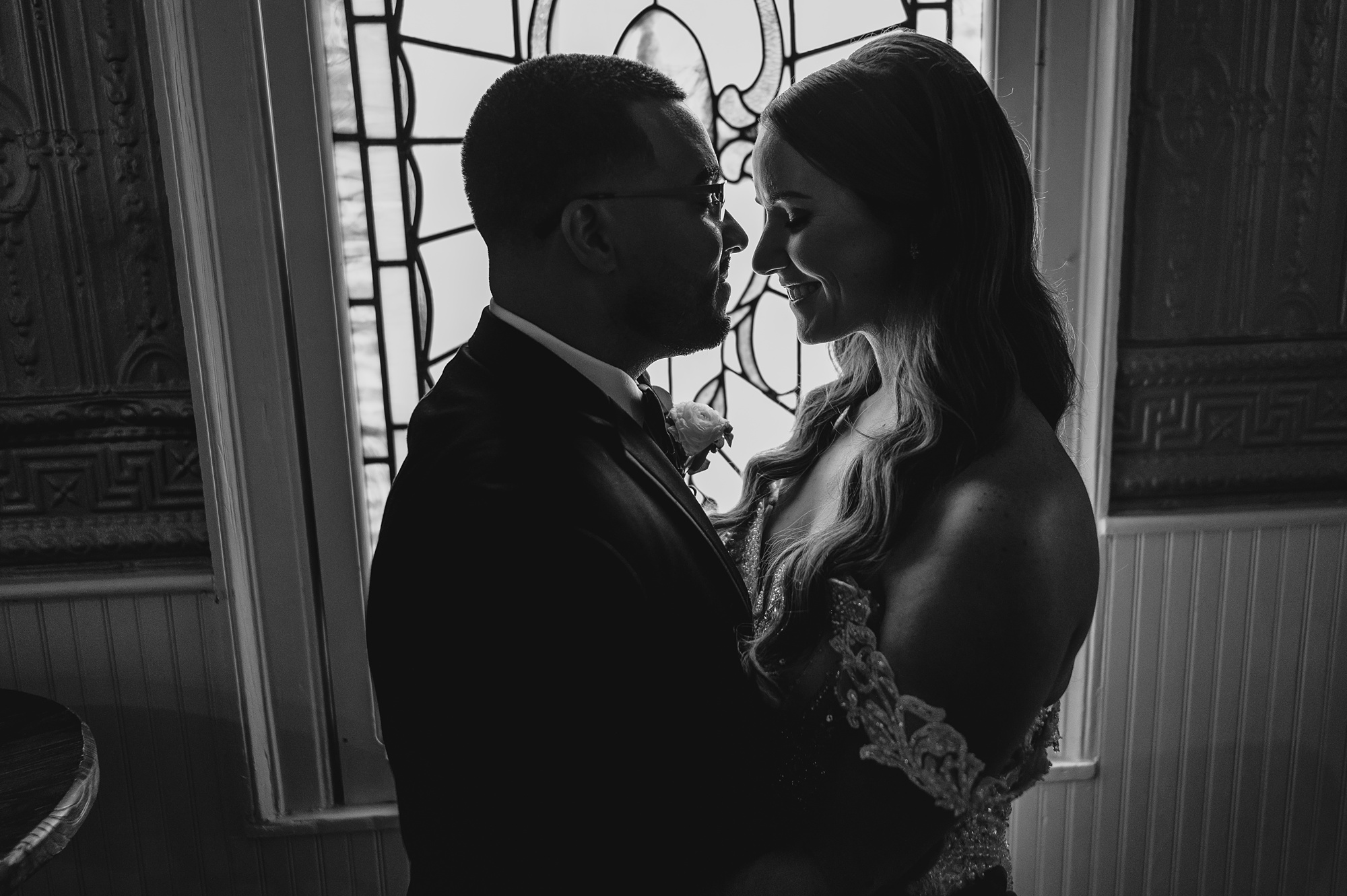 bride and groom hug in front of antique window at David's Country Inn