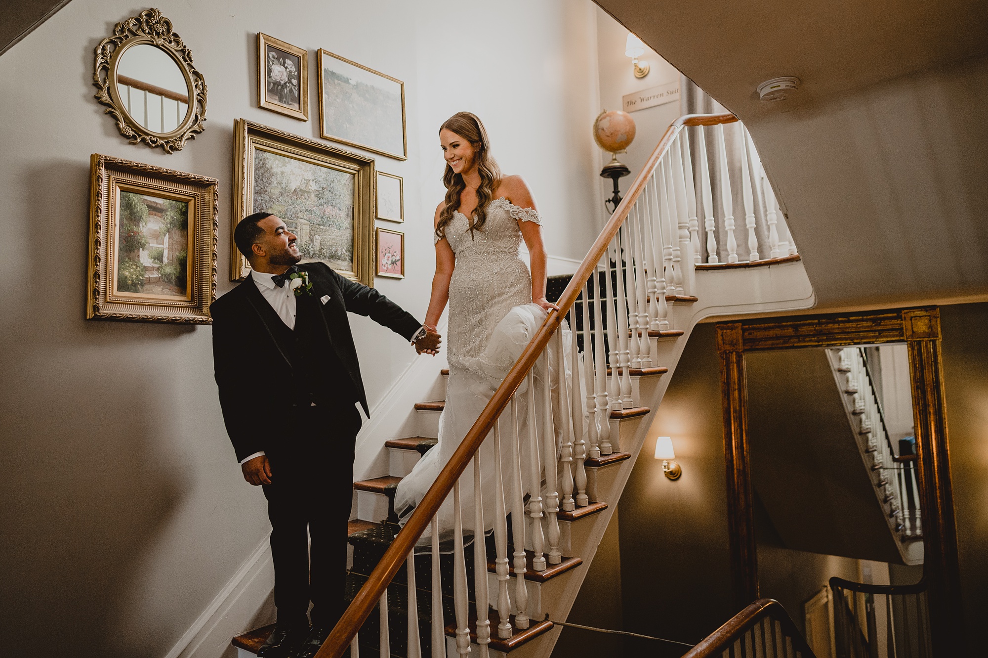 groom leads bride down staircase inside David's Country Inn