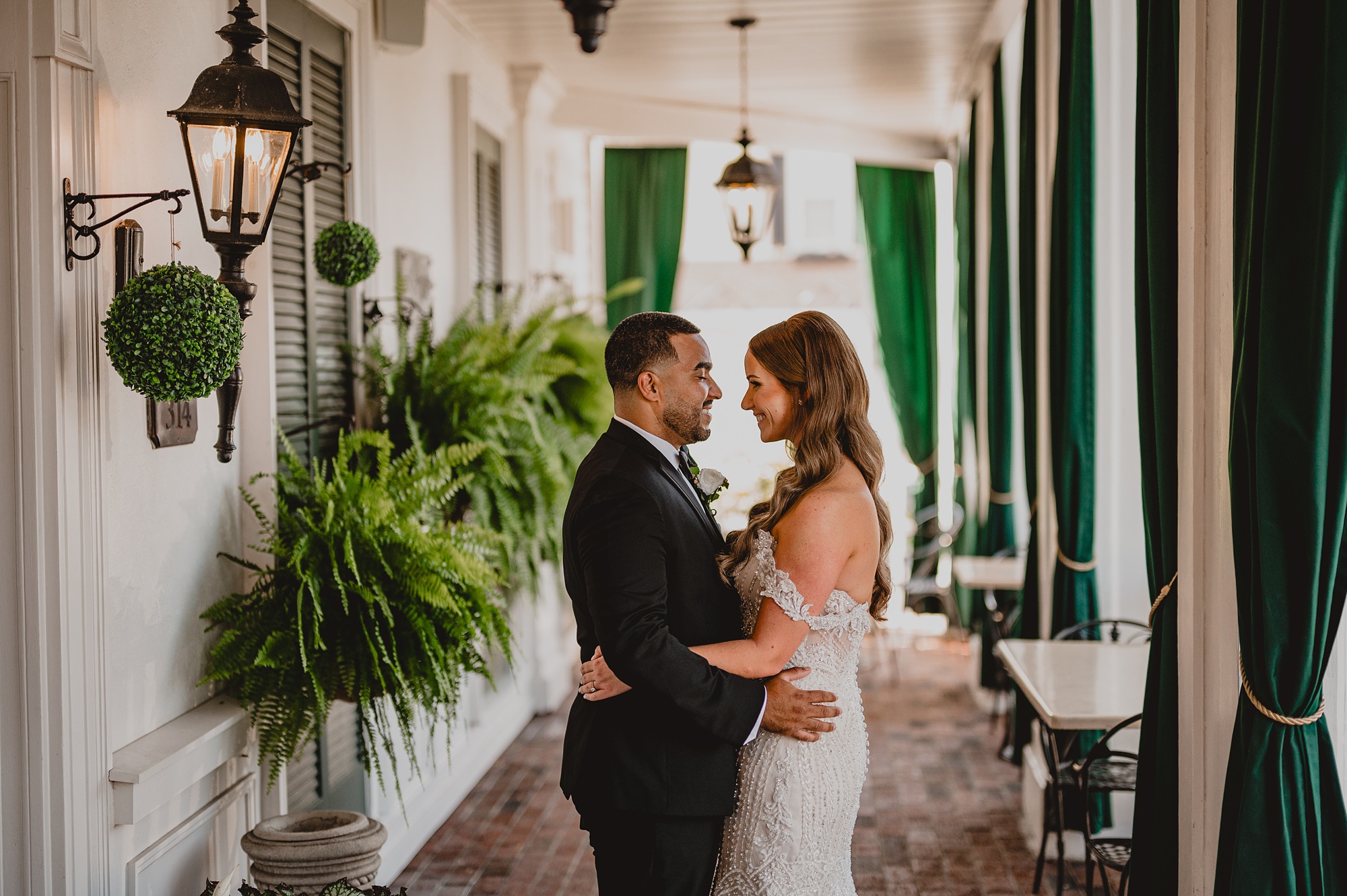 bride and groom hug under covering with green window covers