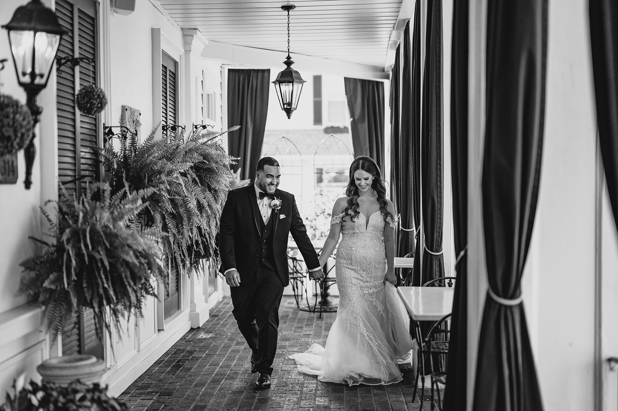 bride and groom hold hands walking under patio at David's Country Inn