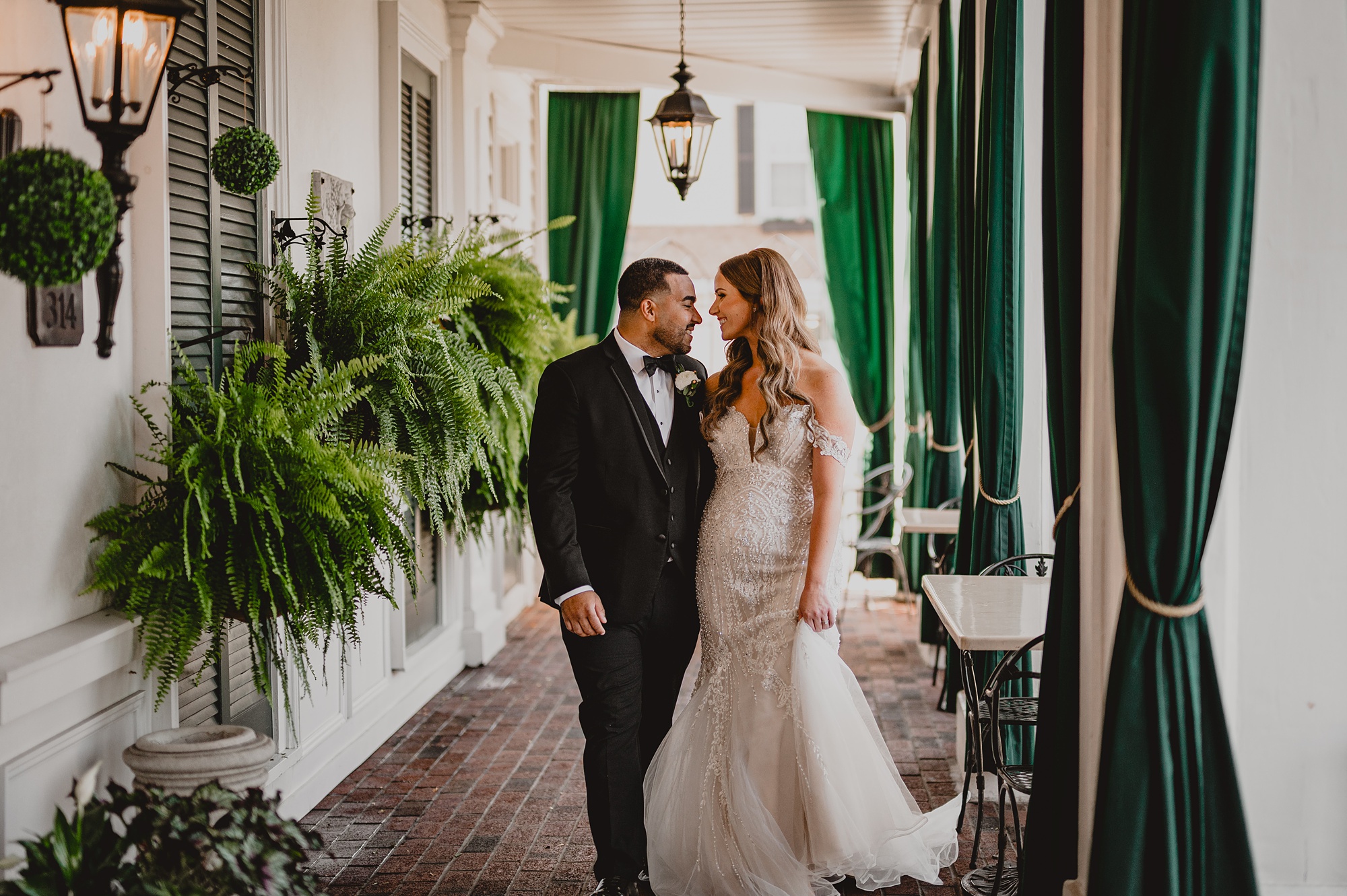 newlyweds hug in front of green doors at David's Country Inn