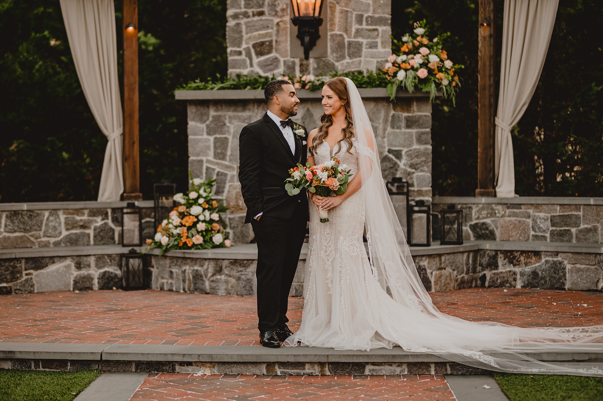 newlyweds pose in front of stone fireplace at David's Country Inn