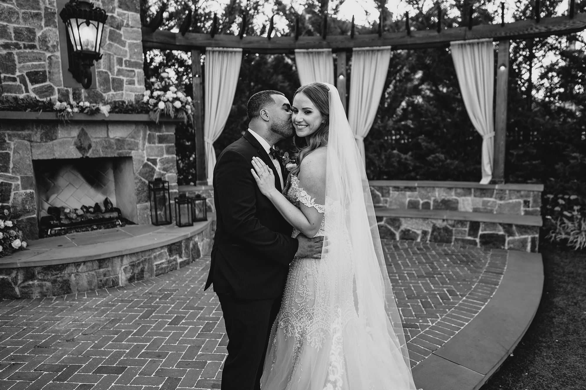 newlyweds hug in front of stone fireplace at David's Country Inn