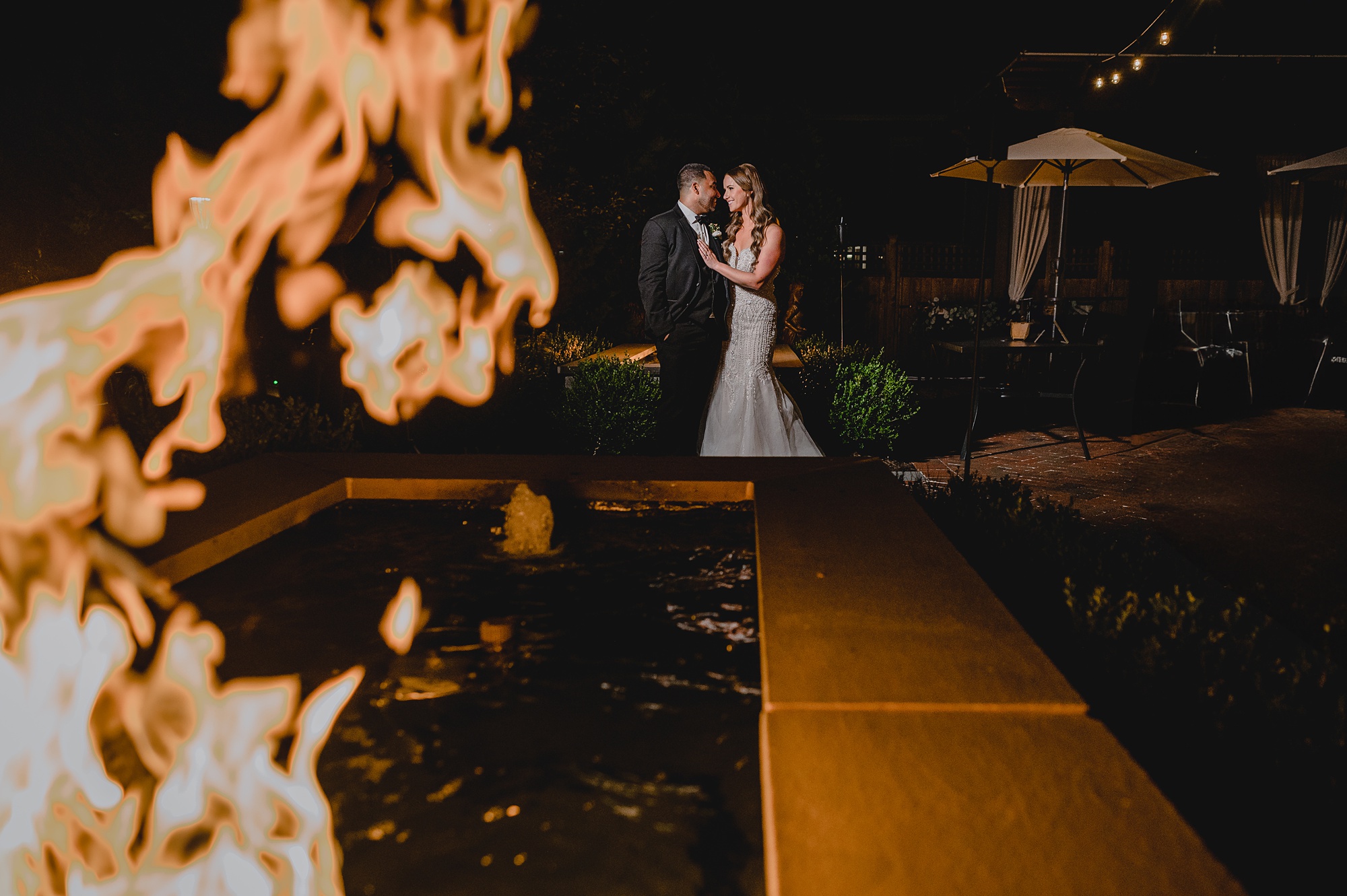 bride and groom stand behind fire pit at David's Country Inn