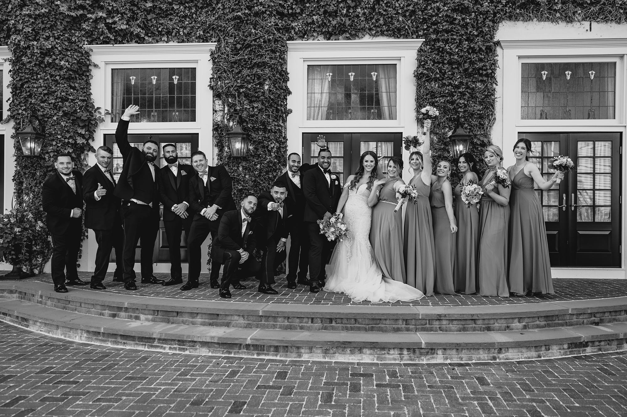 newlyweds pose with wedding party on brick steps at David's Country Inn