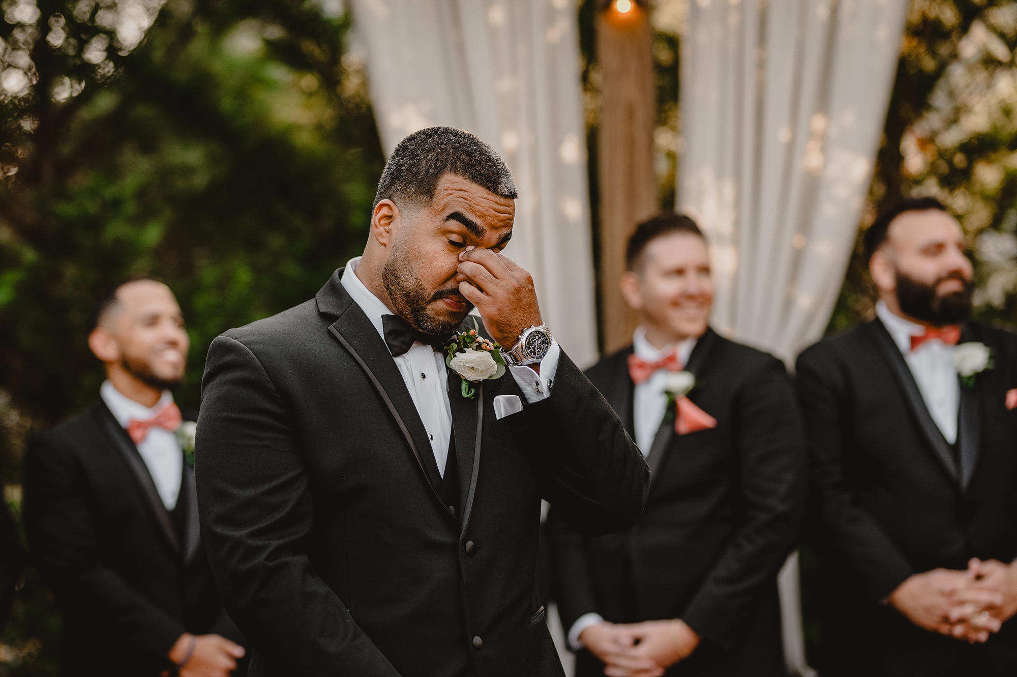 groom holds nose watching bride during ceremony at David's Country Inn