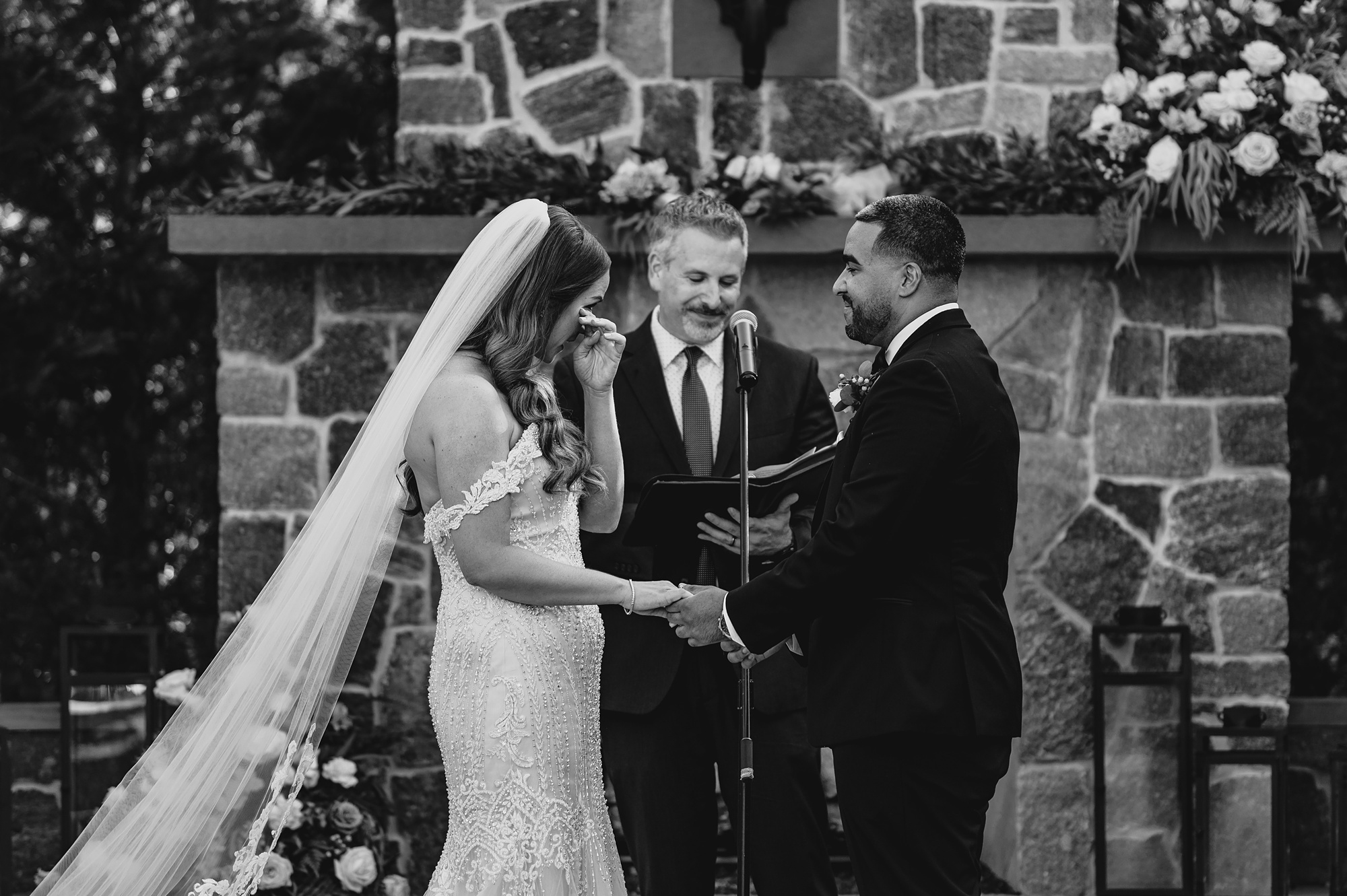 newlyweds old hands during wedding ceremony on brick patio at David's Country Inn