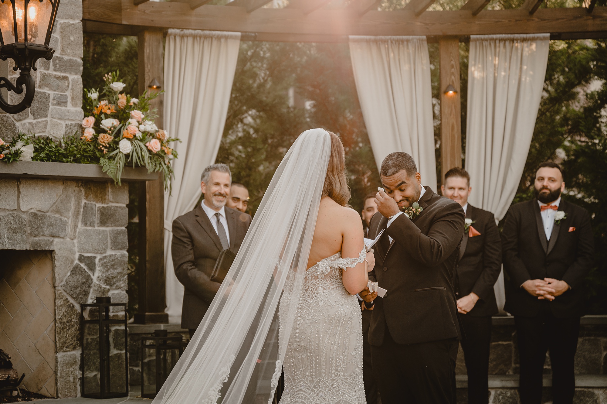 groom cries during wedding ceremony on brick patio at David's Country Inn