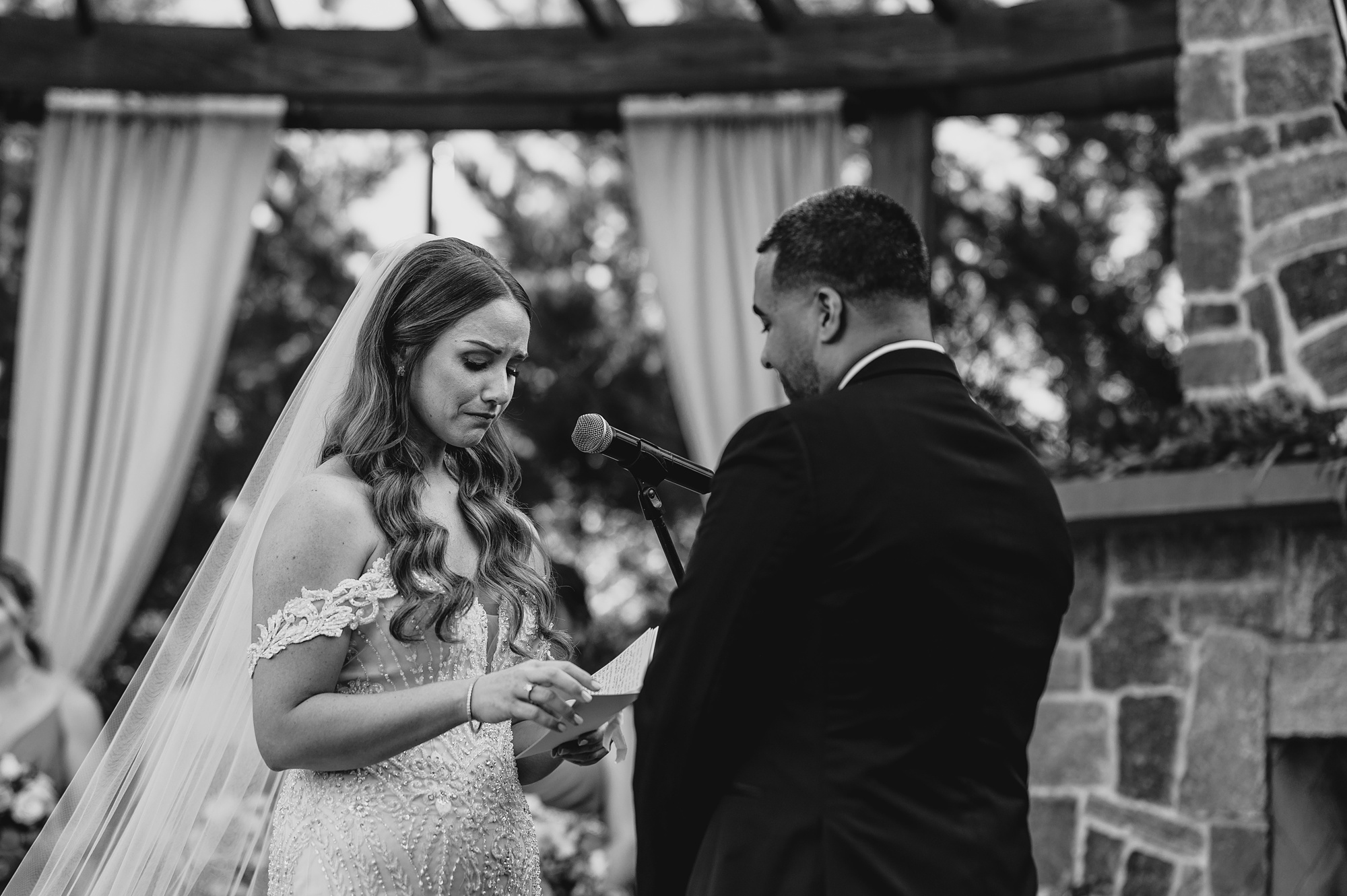 bride reads vows during wedding ceremony on brick patio at David's Country Inn