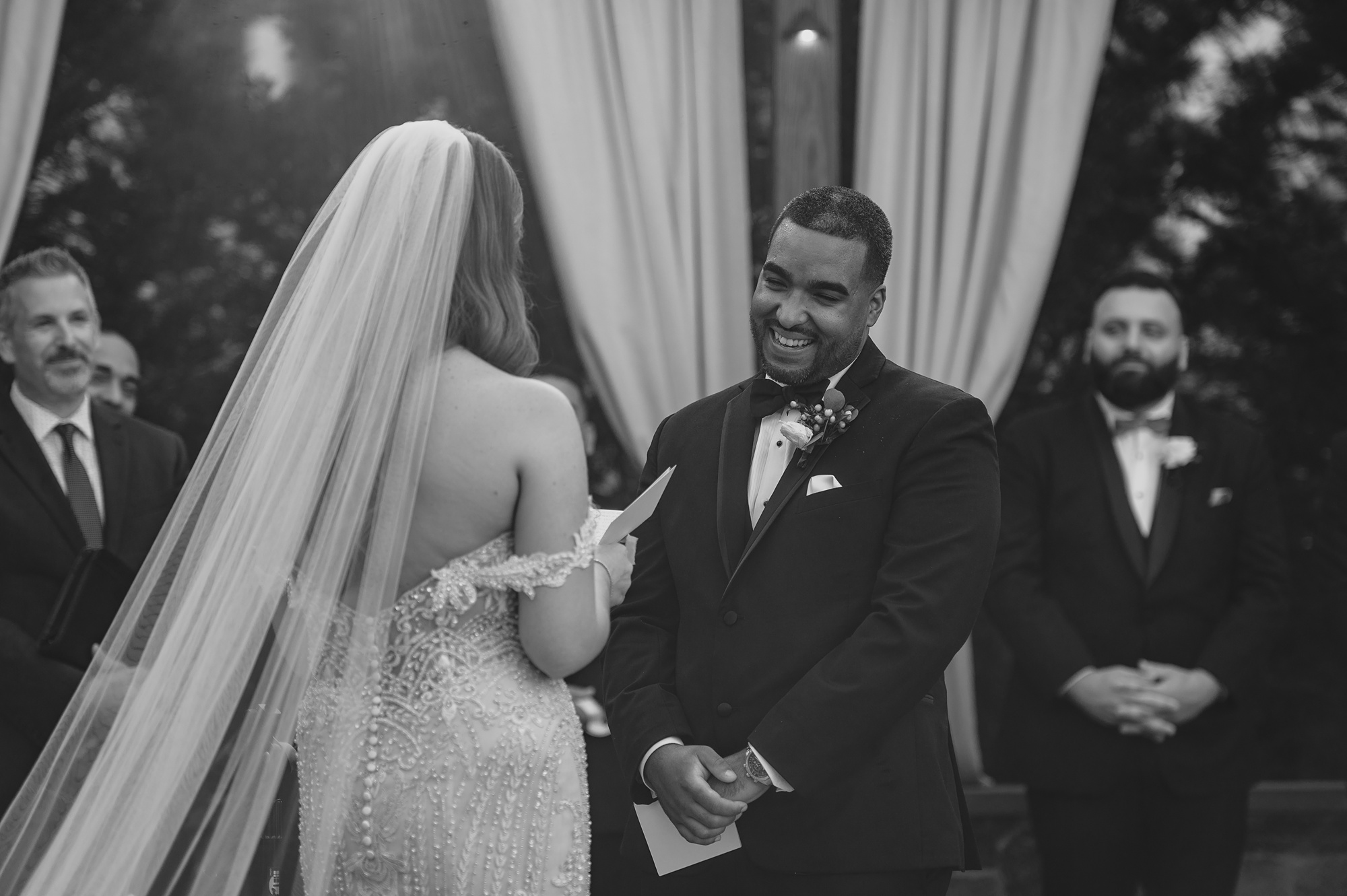 groom laughs at bride during wedding ceremony on brick patio at David's Country Inn