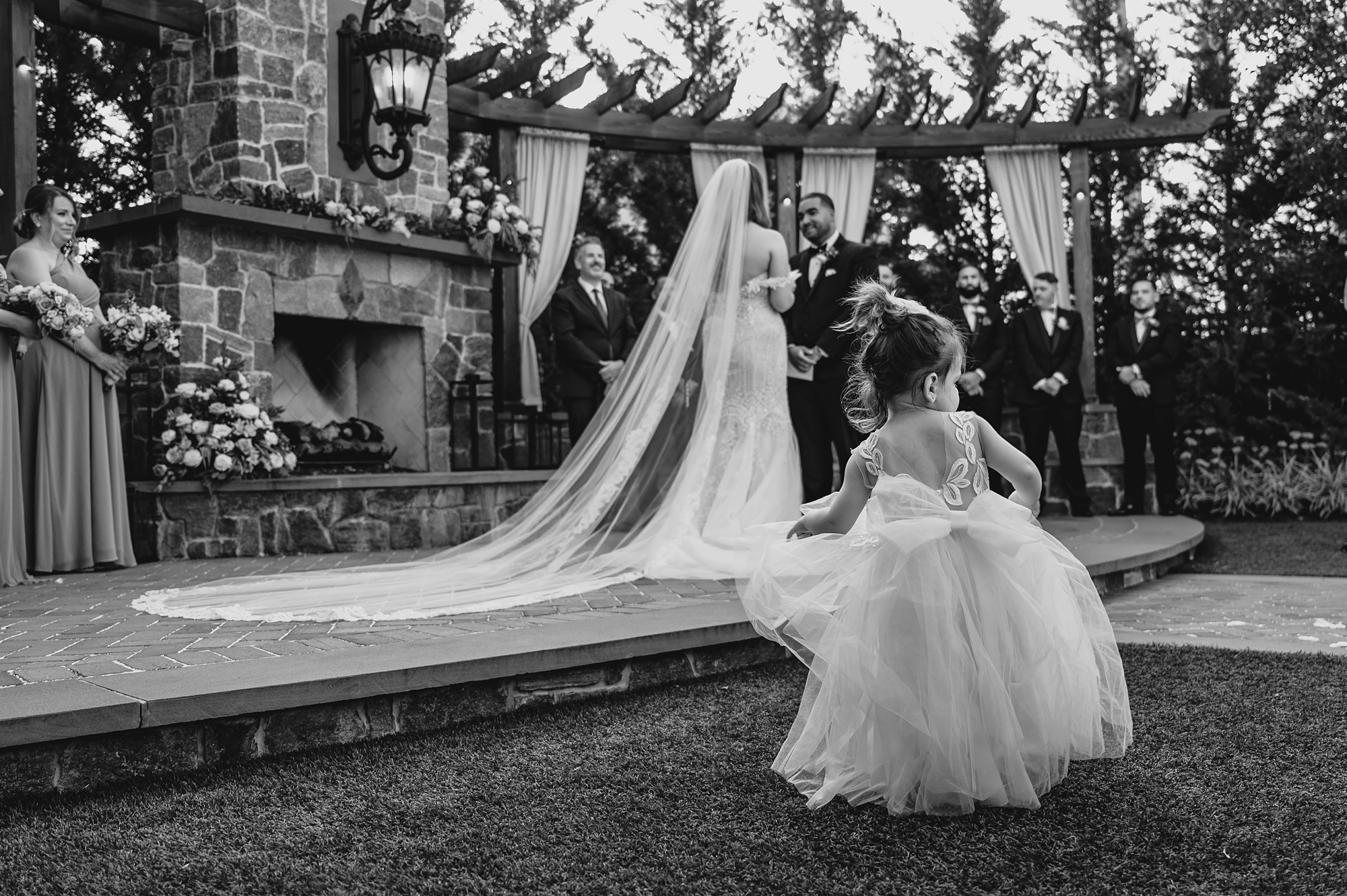 flower girl walks in front of bride and groom during wedding ceremony on brick patio at David's Country Inn