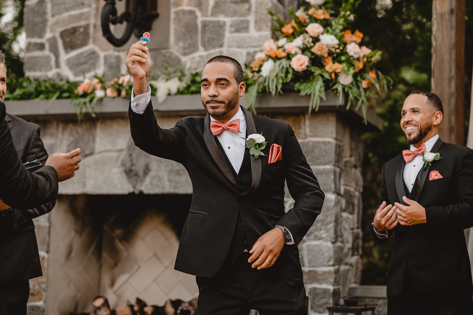 groomsman holds up ring pop during wedding ceremony on brick patio at David's Country Inn