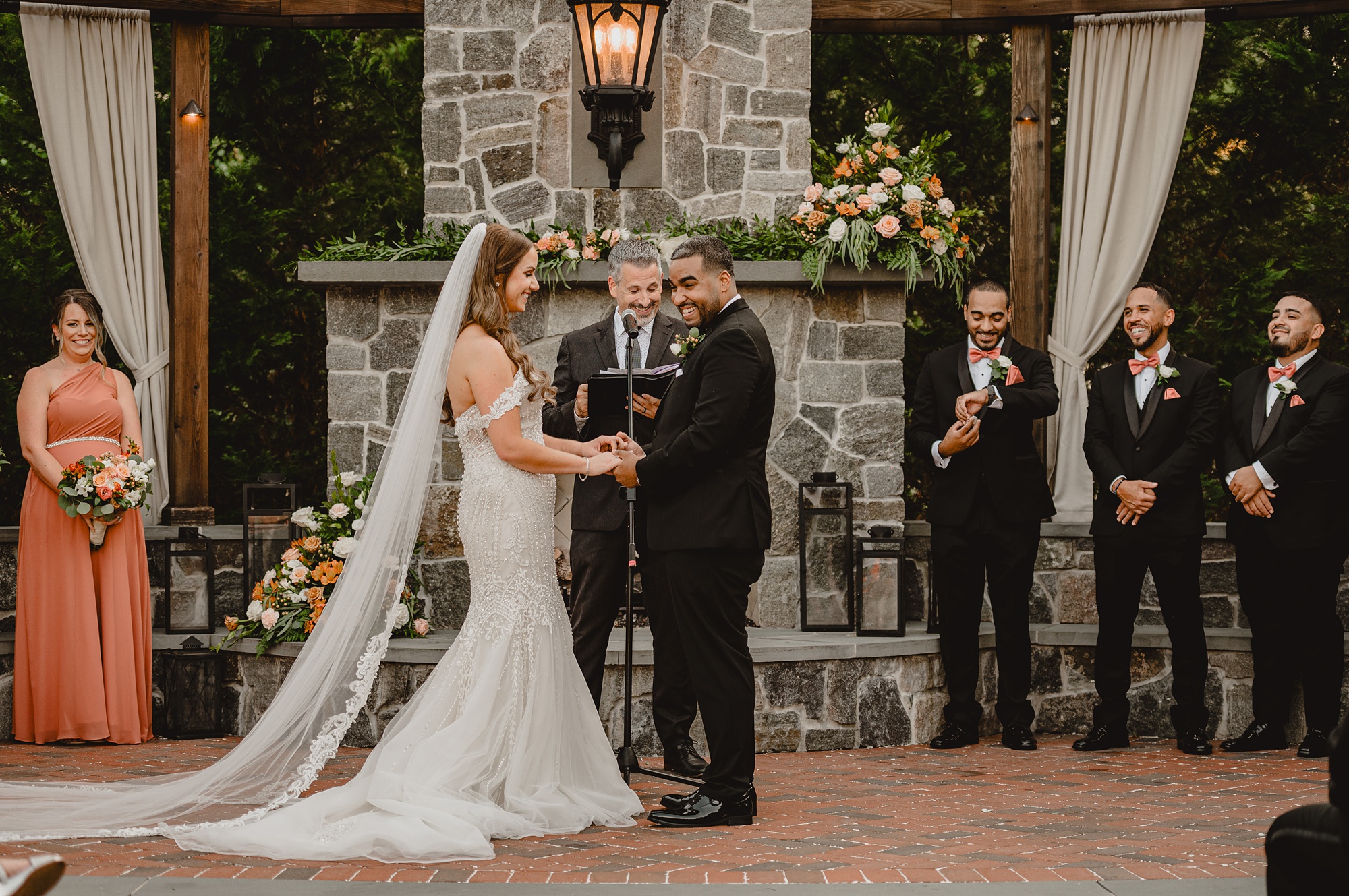 newlyweds hold hands during wedding ceremony on brick patio at David's Country Inn