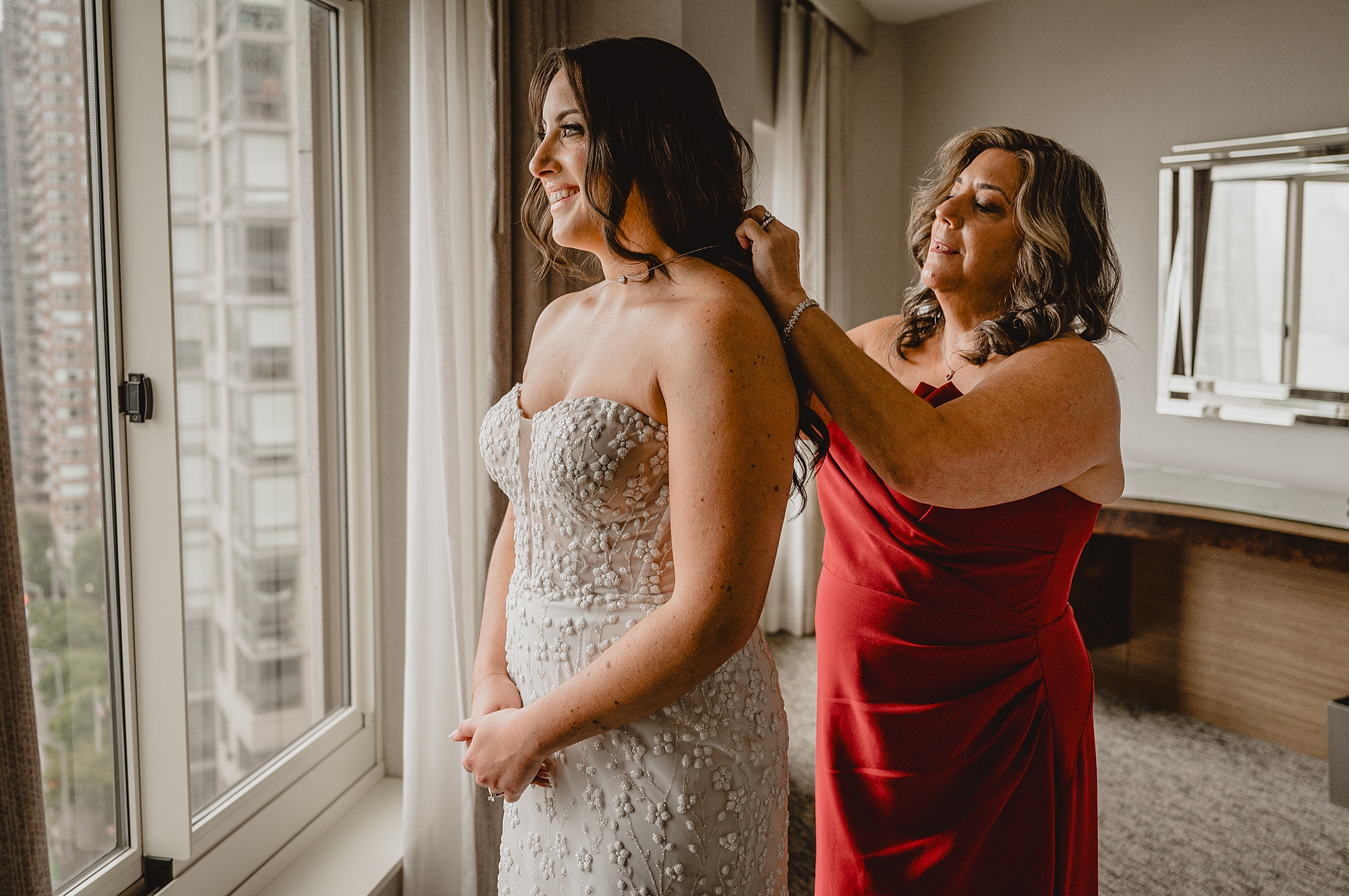 mother helps bride with necklace while preparing for Jersey City wedding