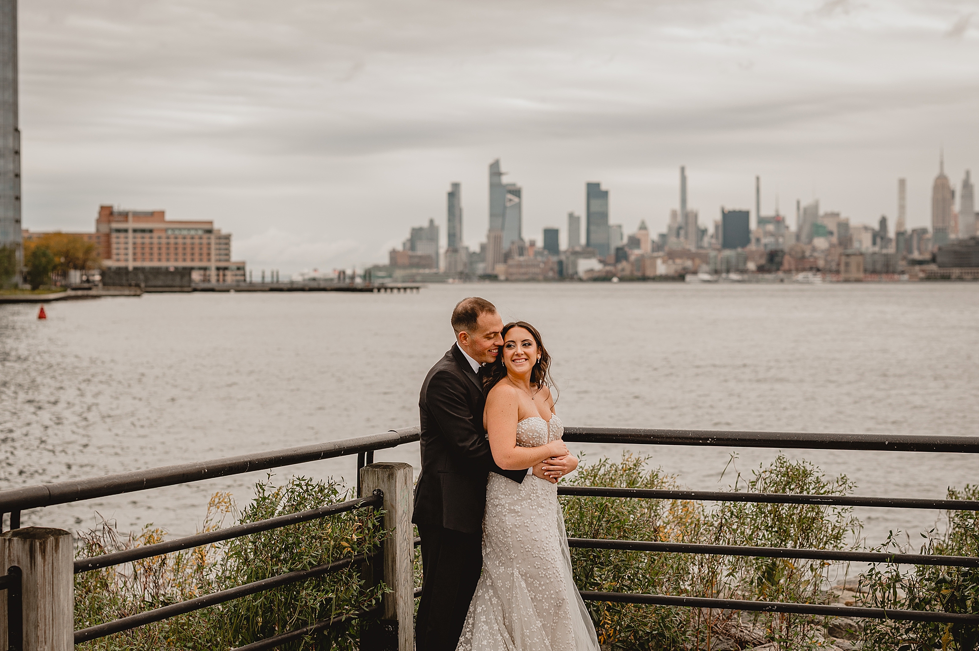 bride and groom hug in corner of patio of the Liberty House