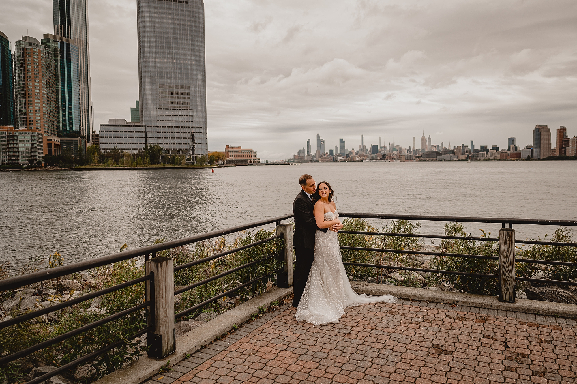 groom hugs bride in corner of patio at the Liberty House