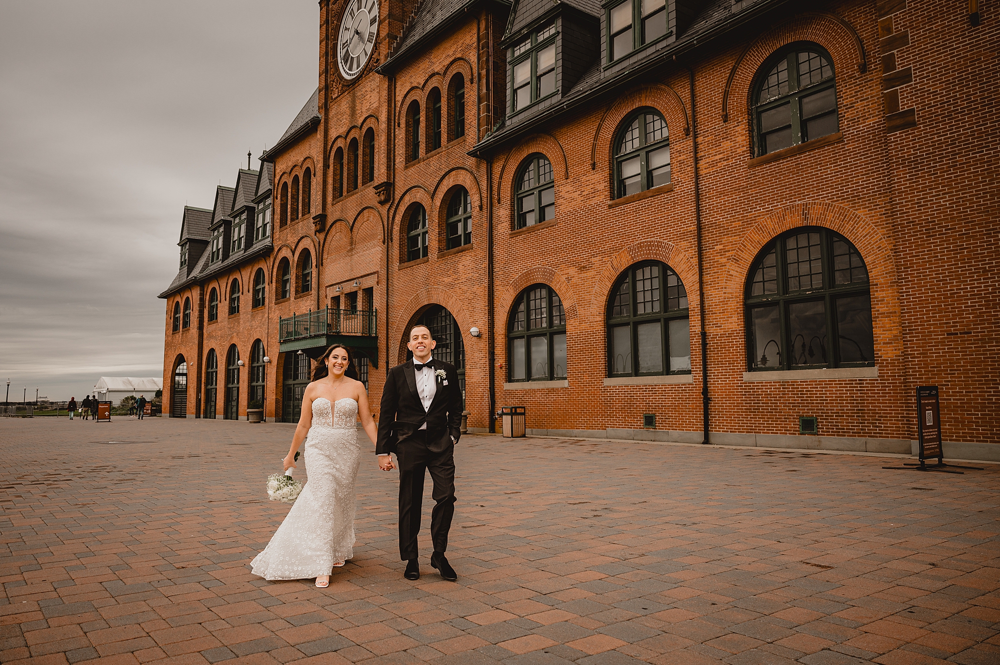 newlyweds walk in front of brick building in Jersey City