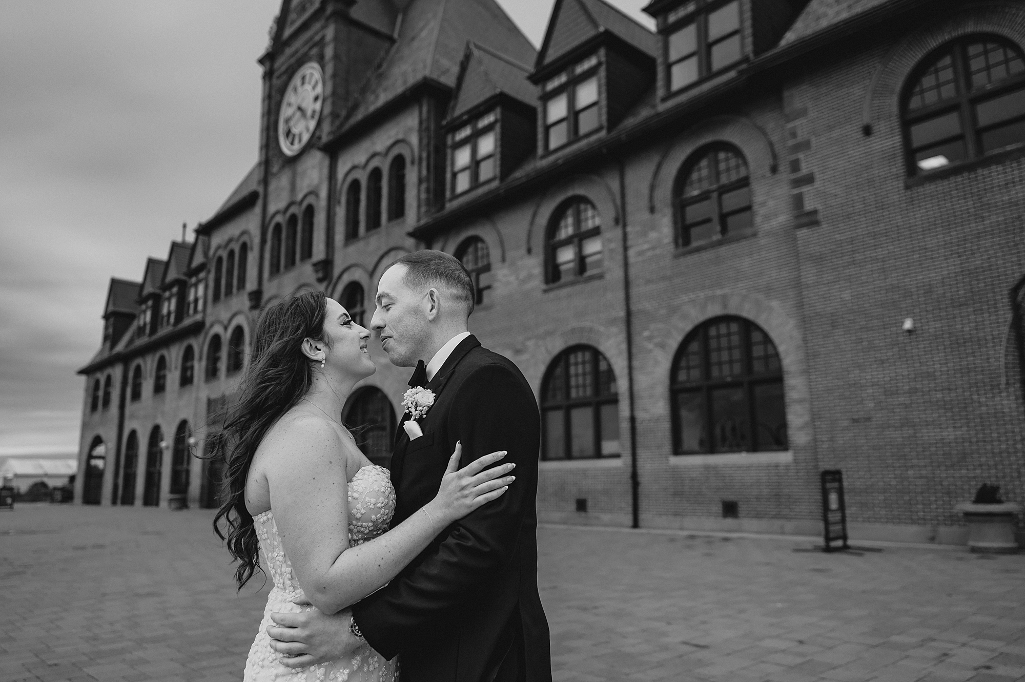 bride and groom kiss standing in front of the Liberty House