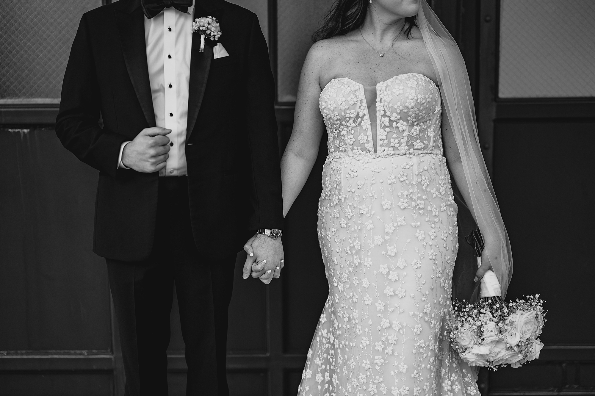 newlyweds hold hands standing in front of the Liberty House