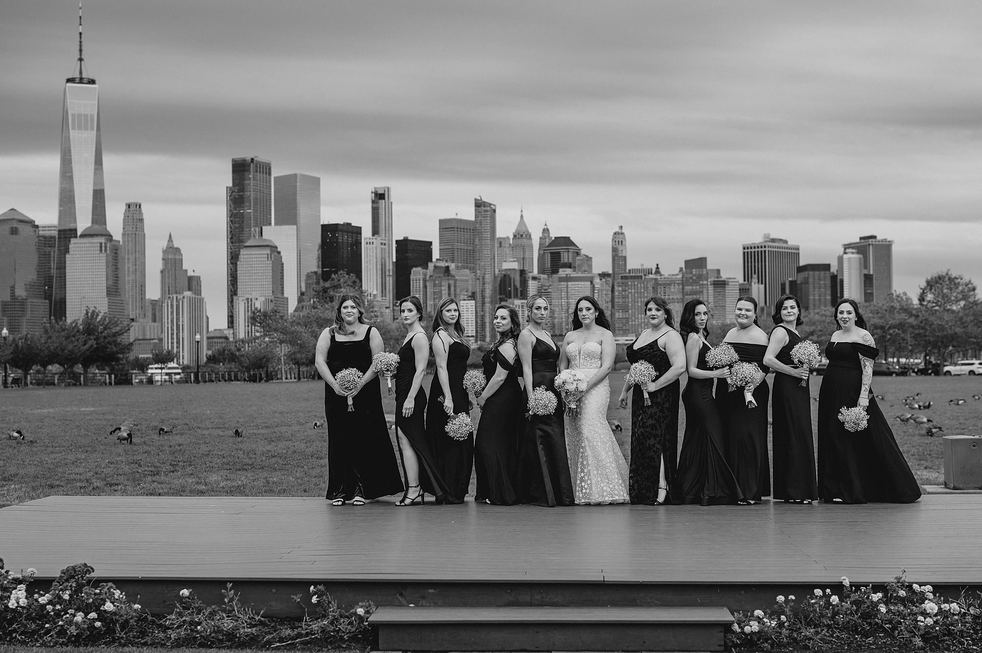bride stands with bridesmaids on patio with NYC skyline behind them