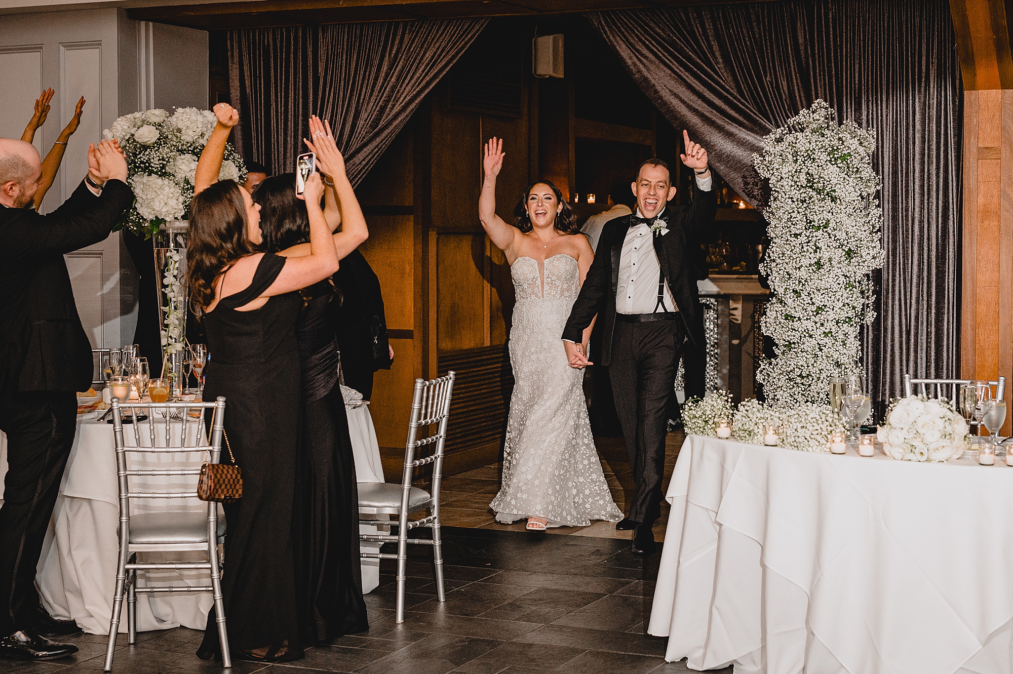 bride and groom cheer walking into wedding reception in Jersey City