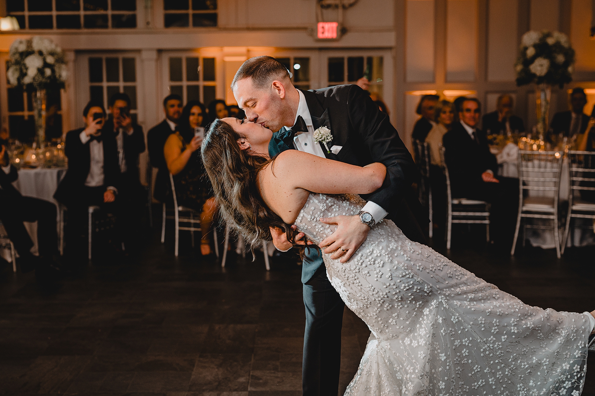 groom dips bride kissing her on dance floor at the Liberty House