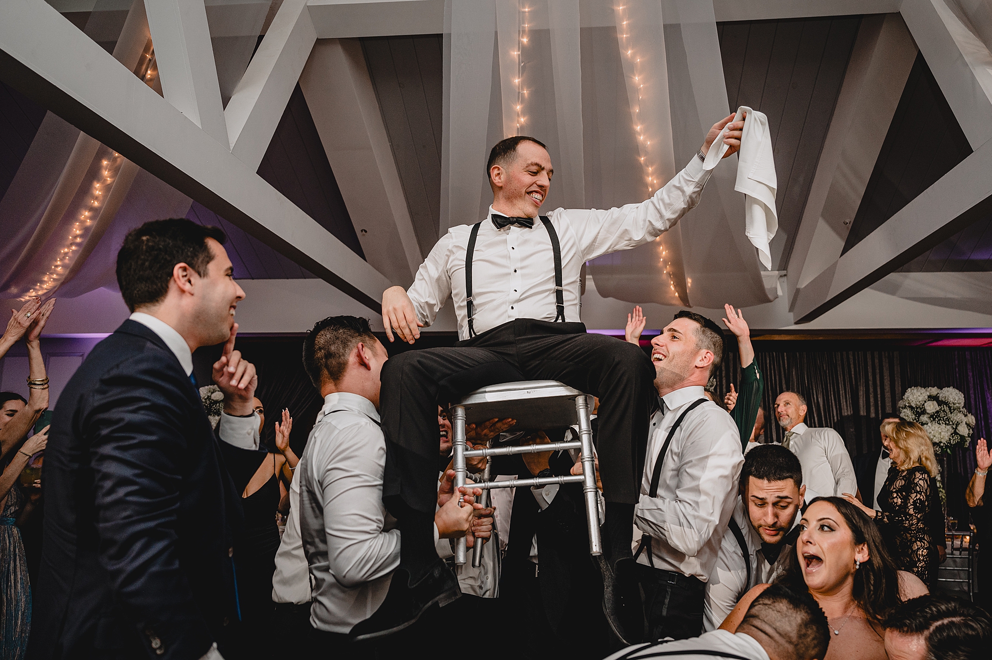 wedding guests lift up bride and groom during hora at the Liberty House
