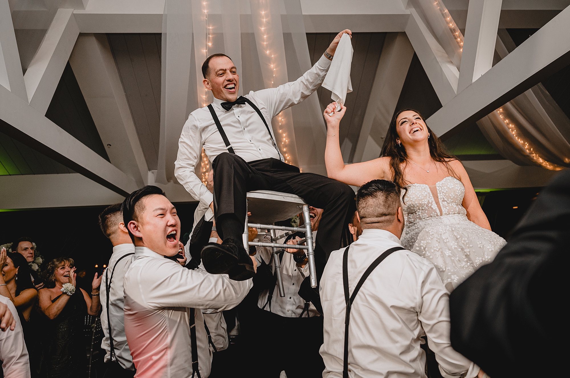 wedding guests lift up bride and groom during hora at the Liberty House wedding reception