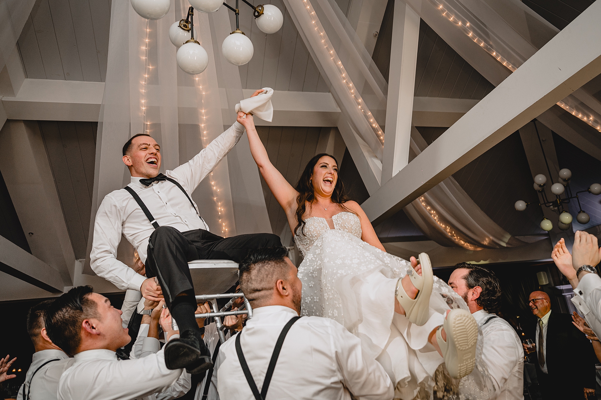 wedding guests lift up bride and groom during hora at the Liberty House