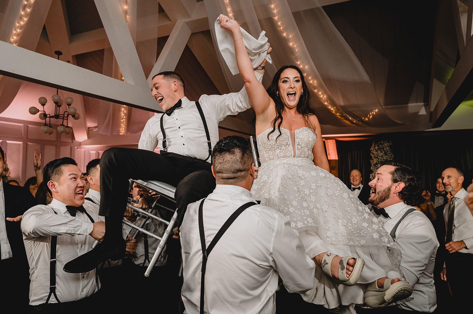 wedding guests lift up bride and groom during hora at the Liberty House wedding reception