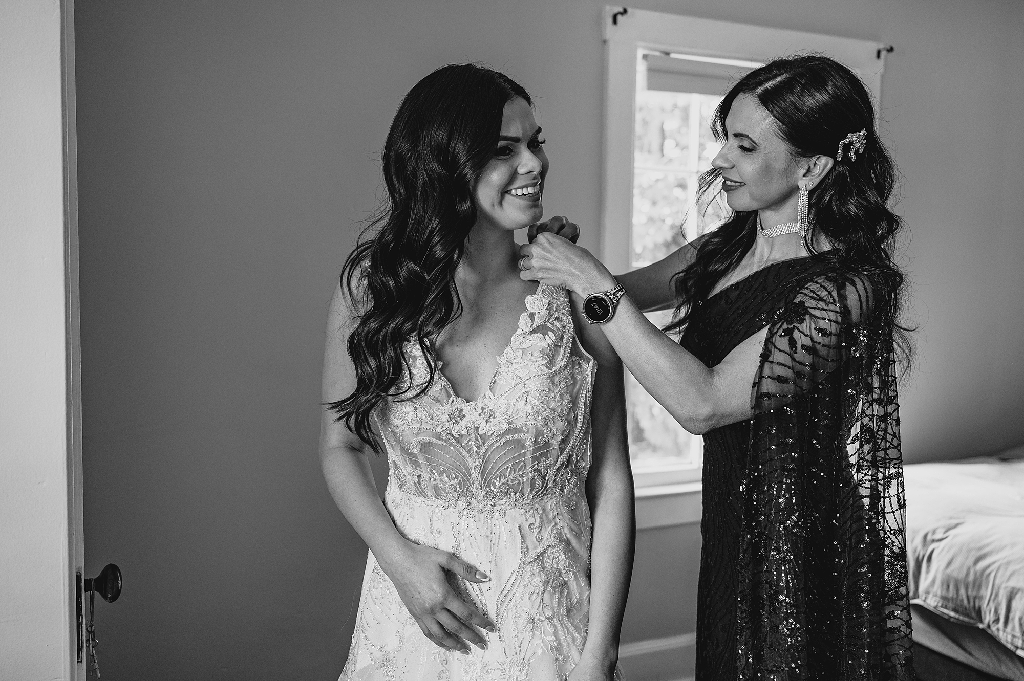 woman helps bride into wedding dress for New York celebration