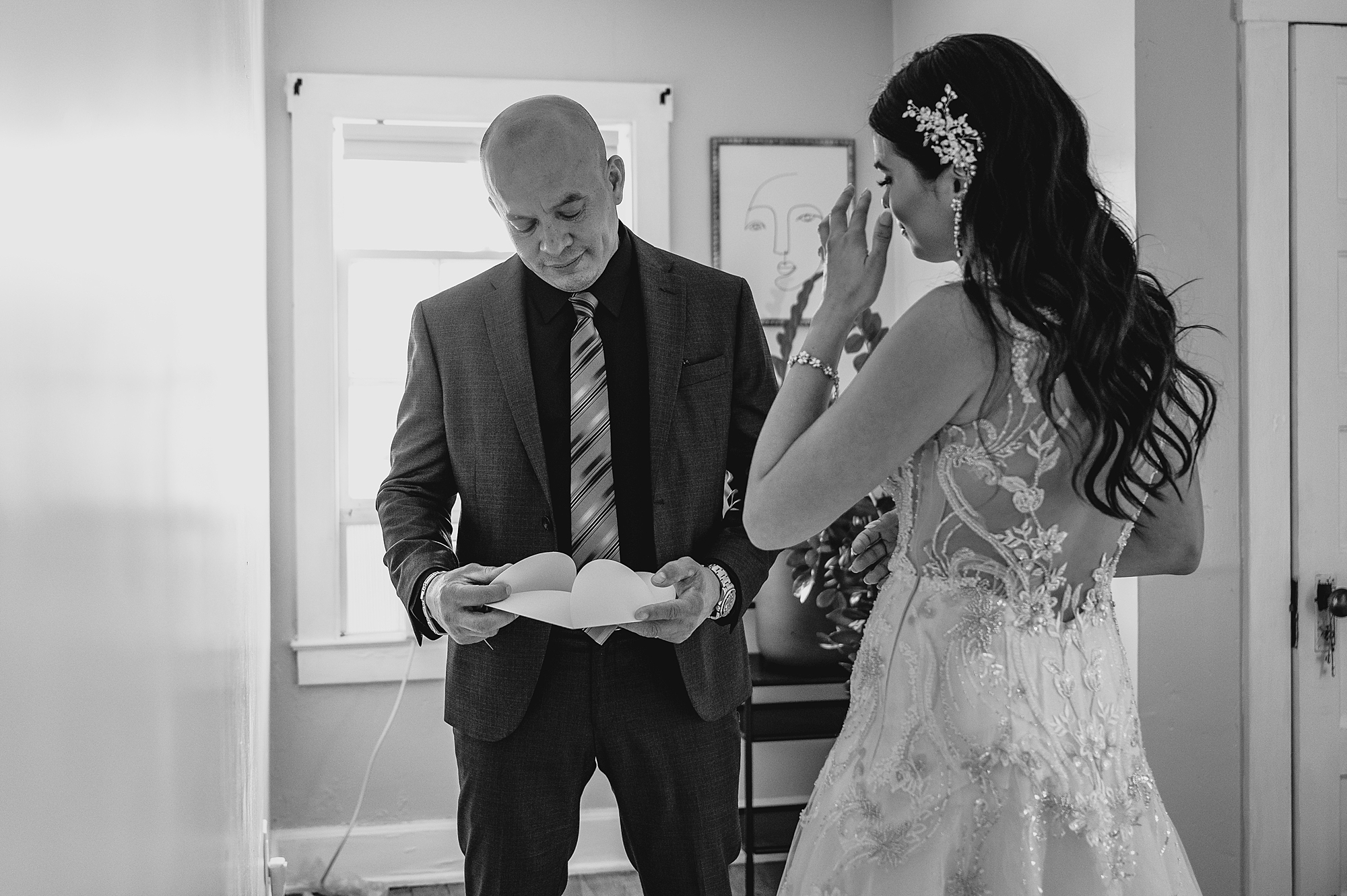 bride wipes away tears during first look with father at wedding at the Garrison