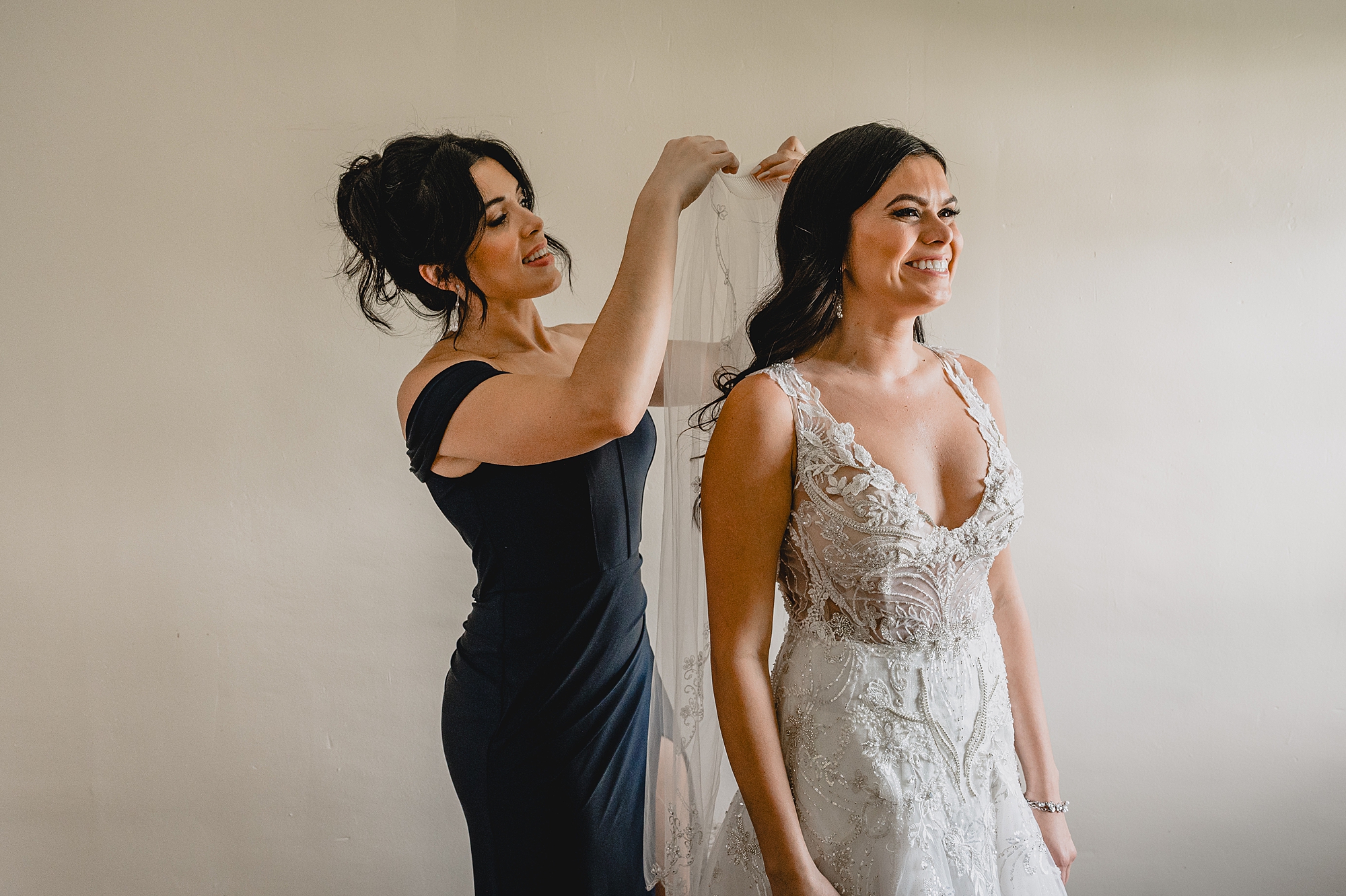 mother puts veil in hair for bride on wedding day