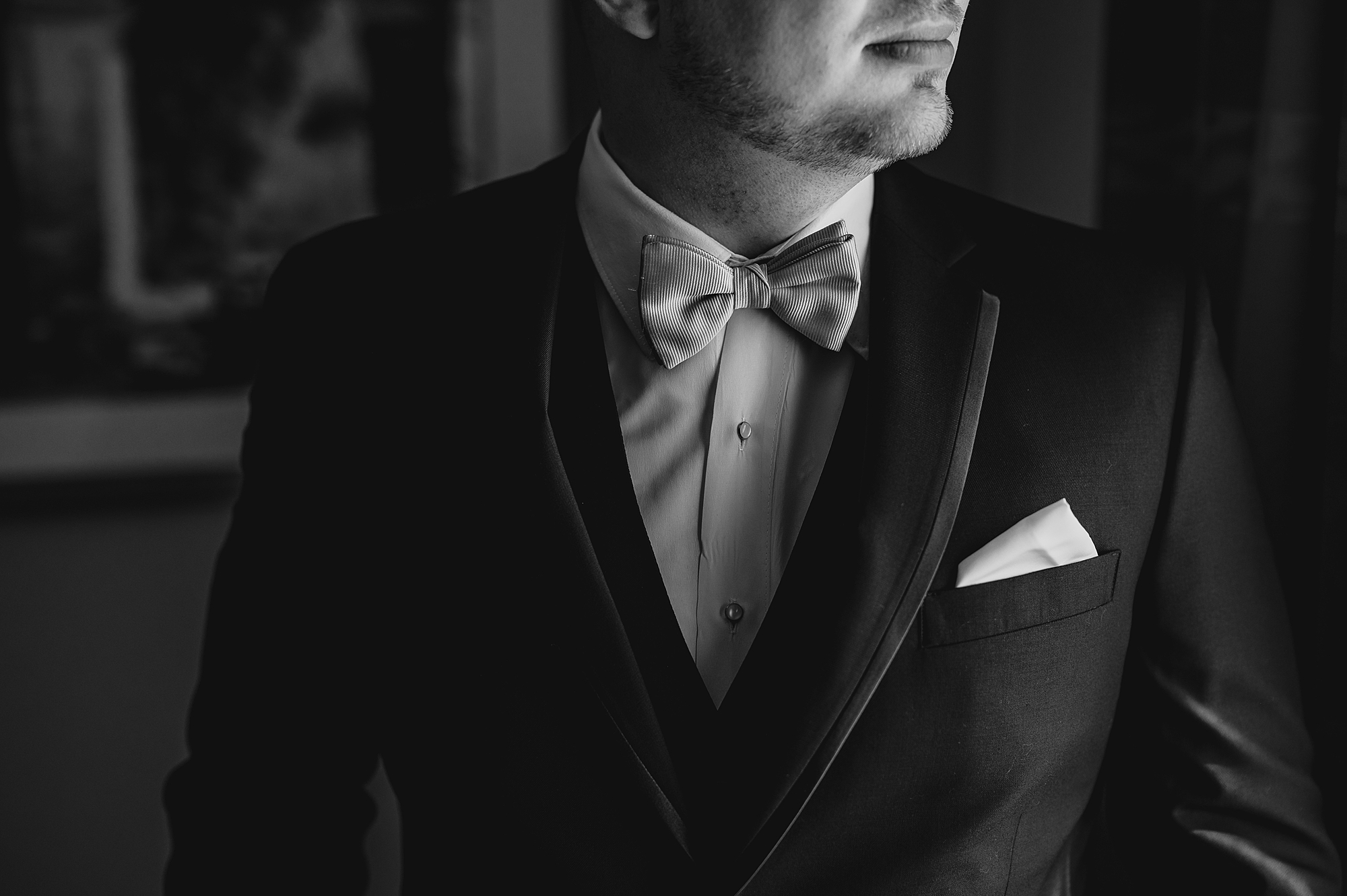 close up of groom's bow tie in black suit