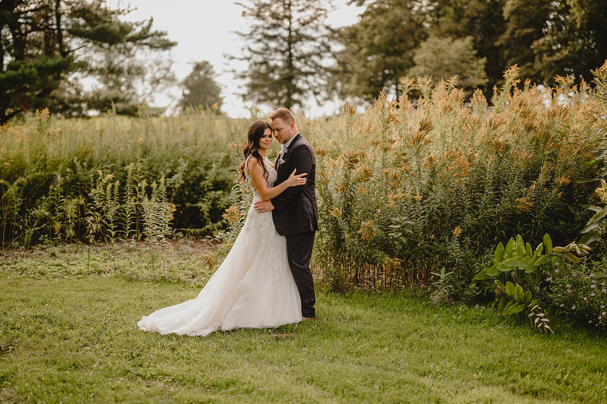 groom hugs bride leaning his head into her forehead at the Garrison
