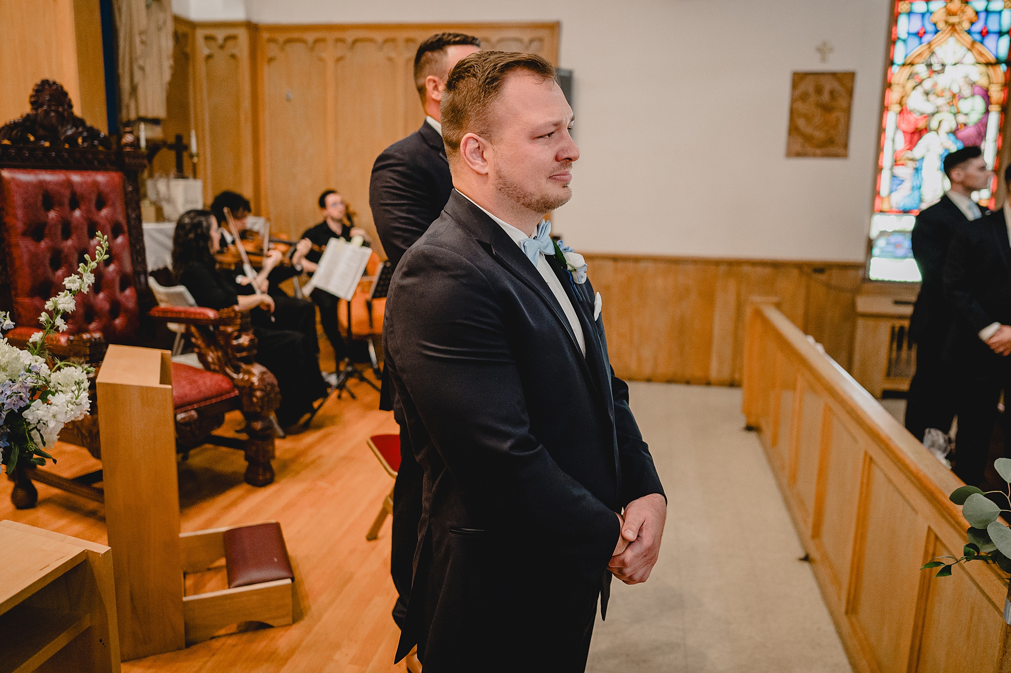 groom waits for bride at the end of the aisle for traditional church ceremony