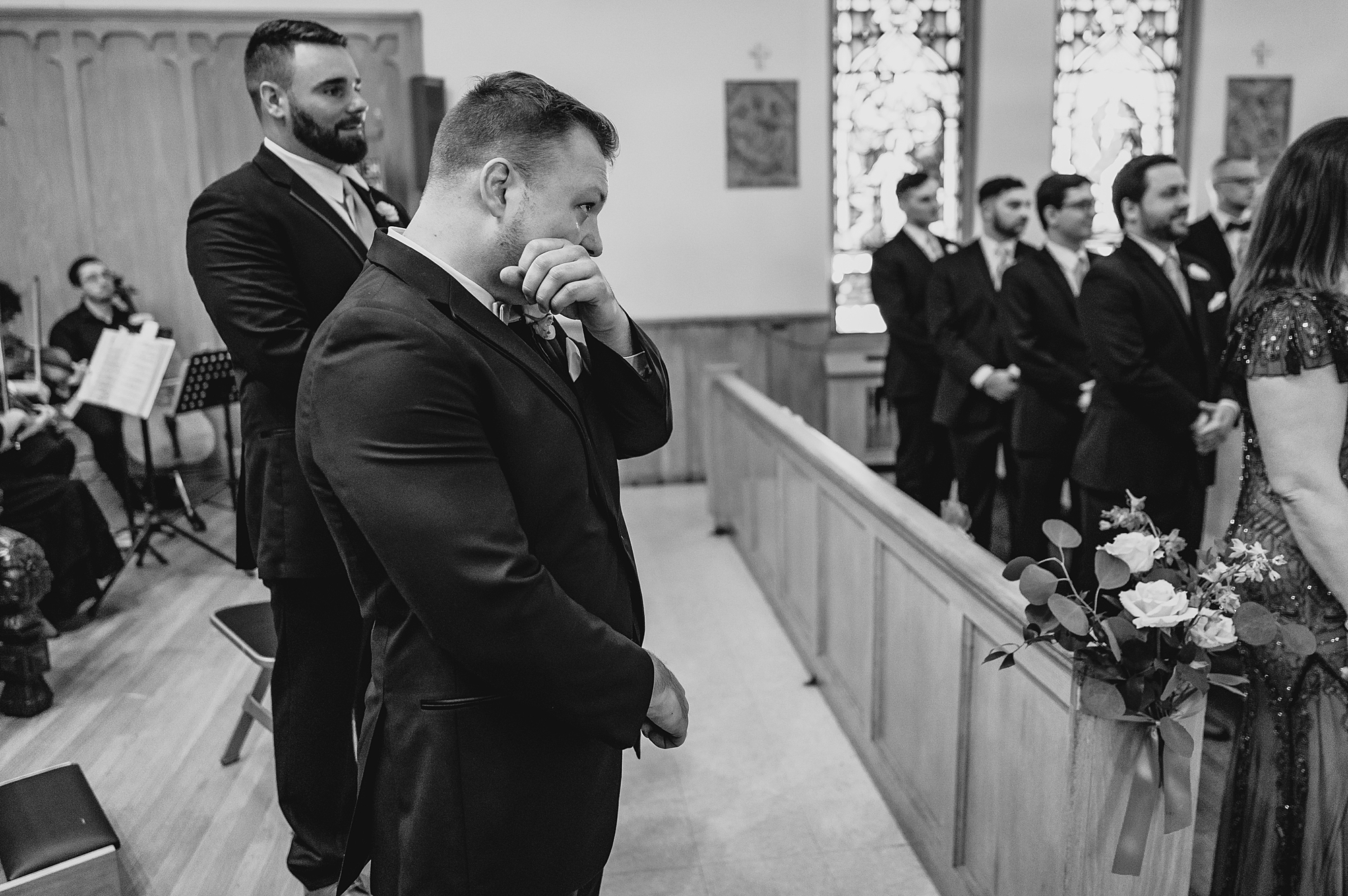 groom wipes away tears during ceremony in church