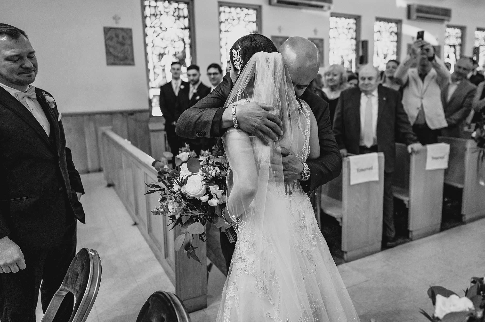 father hugs bride during traditional church ceremony