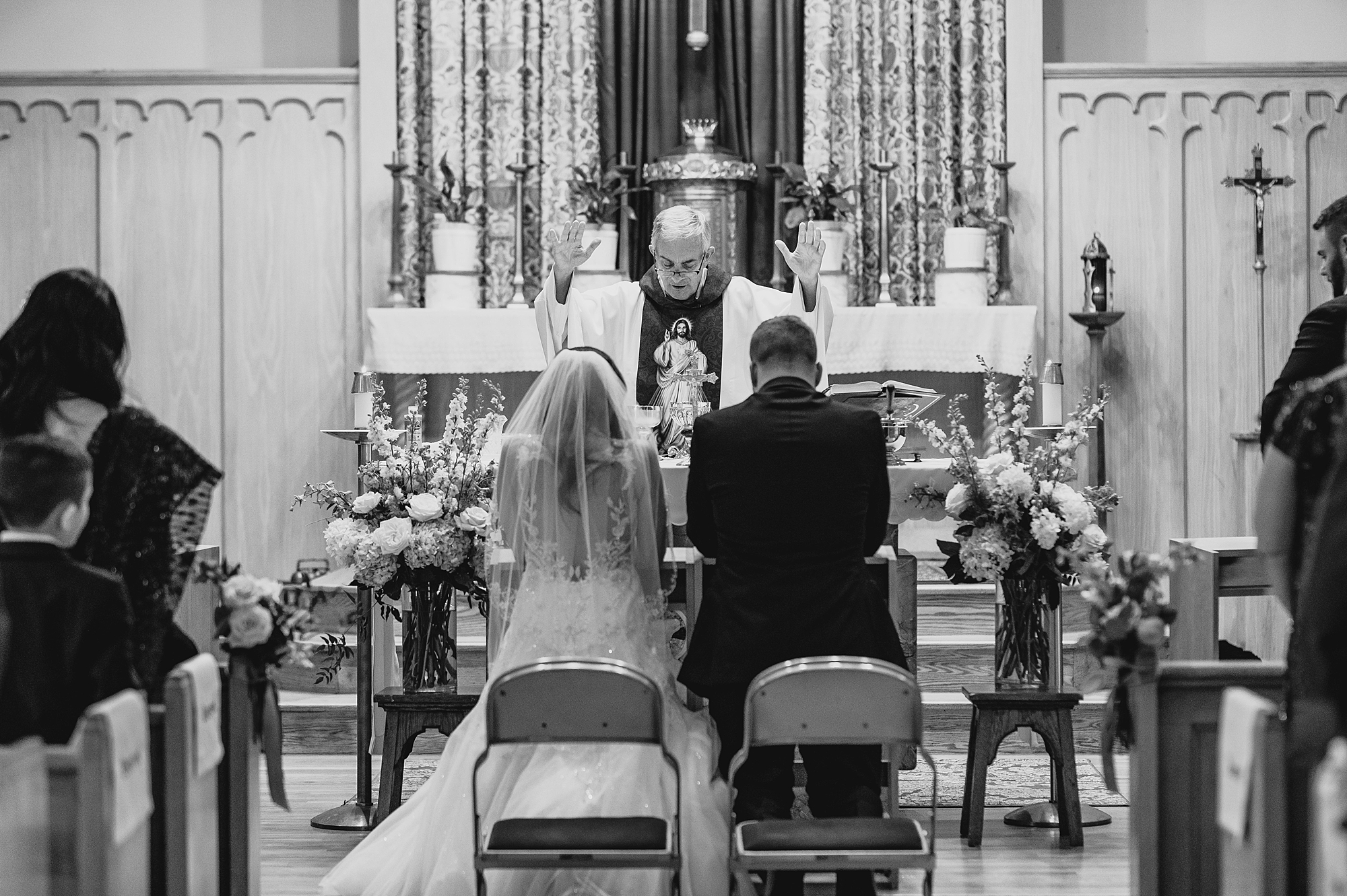 bride and groom kneel at alter during traditional church ceremony
