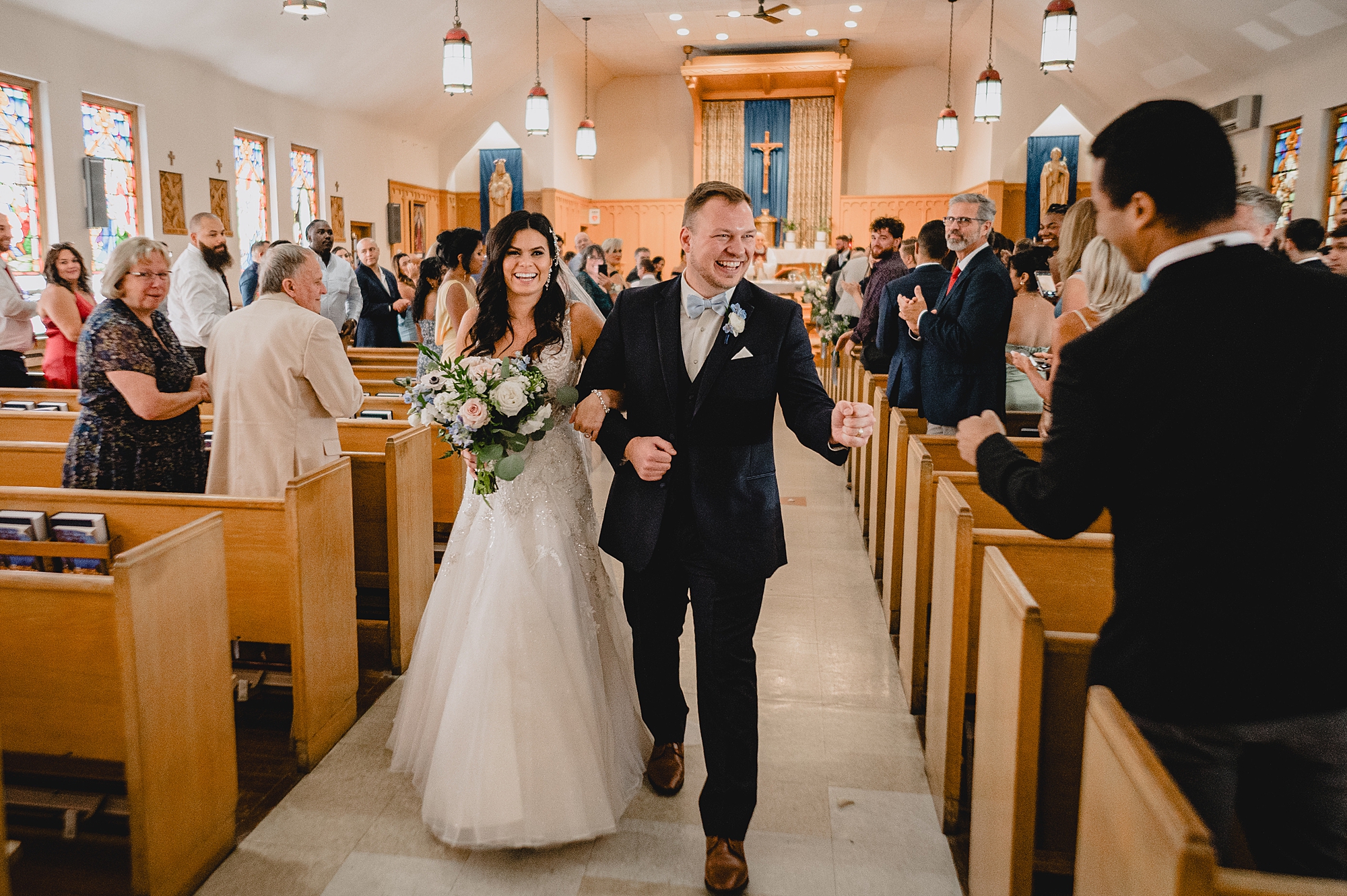 newlyweds greet guests while leaving traditional church ceremony