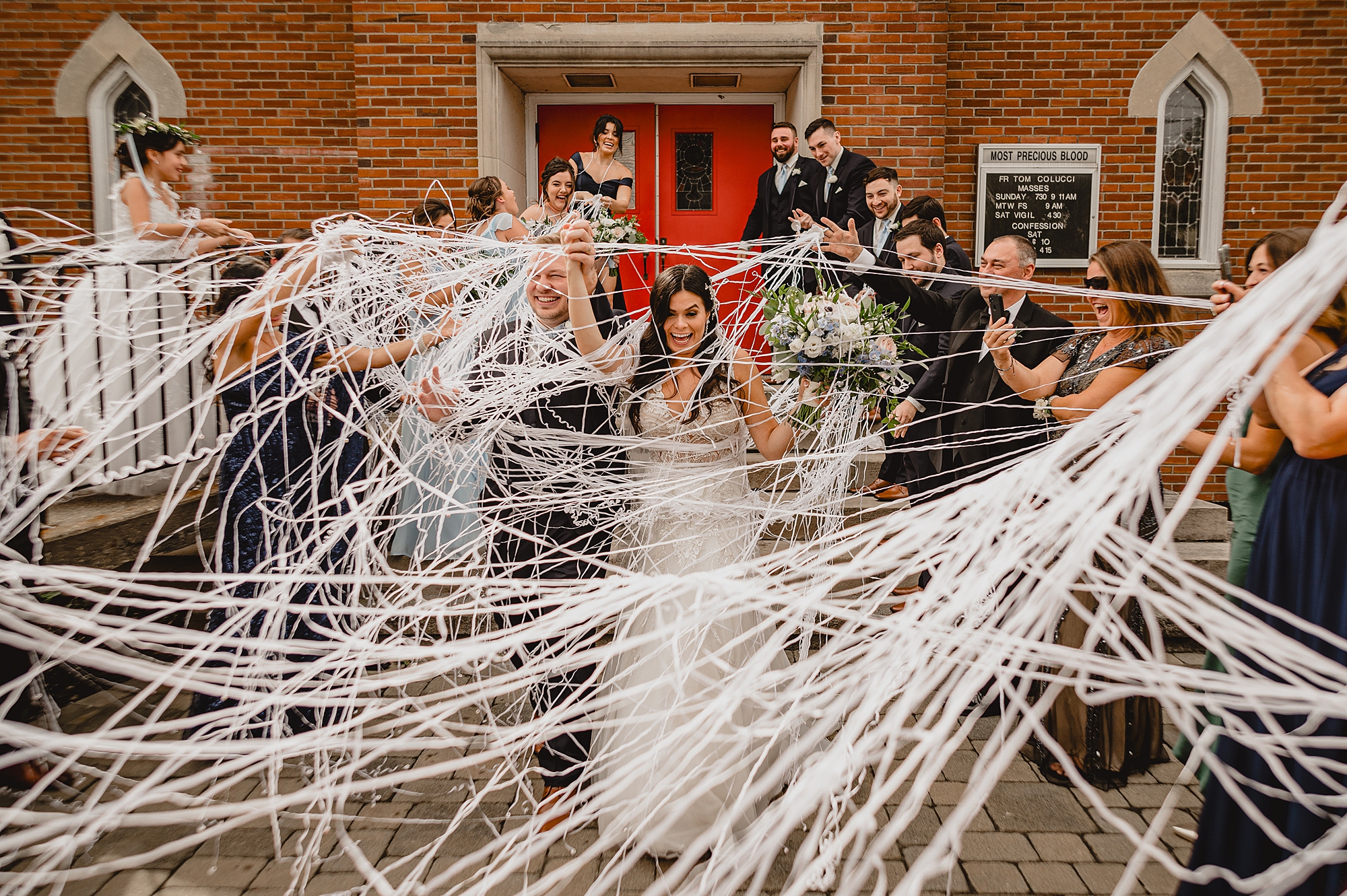 wedding party shoots silly string at bride and groom leaving church