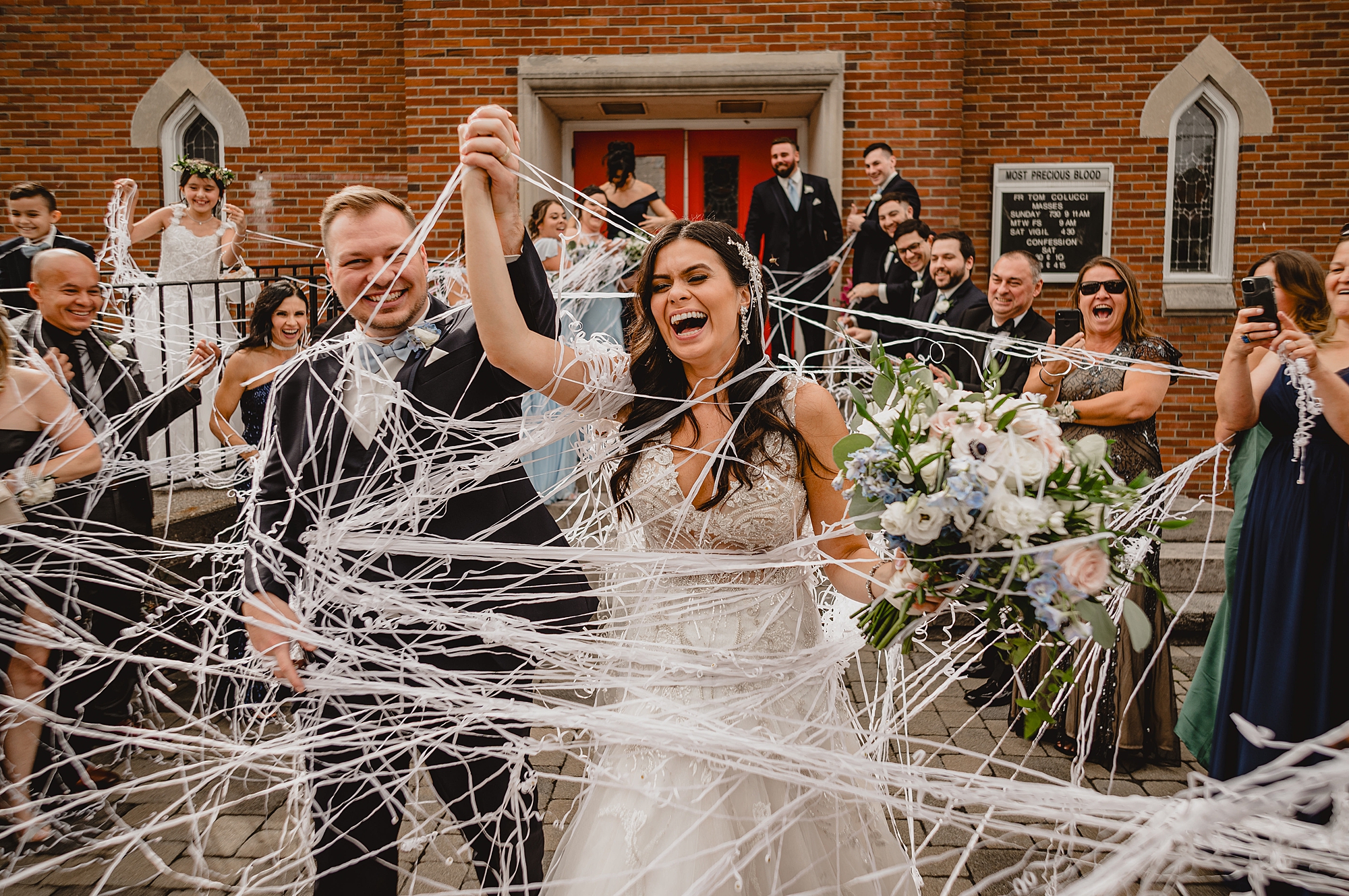 wedding party shoots silly string at bride and groom leaving church