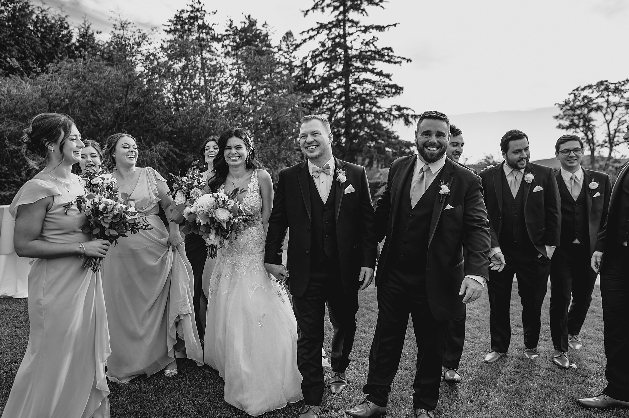 bride and groom walk with wedding party on lawn in Garrison NY